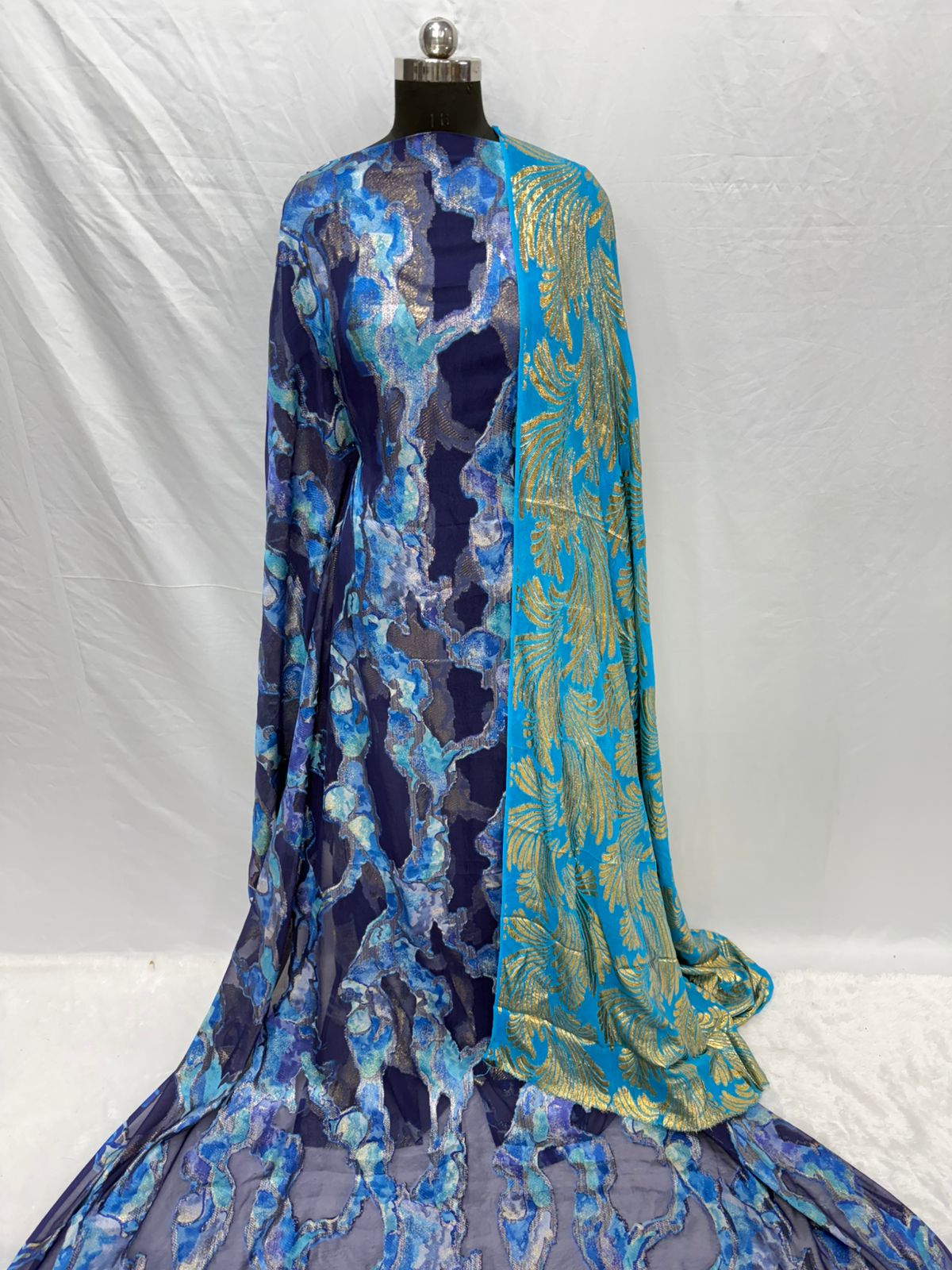 Blue and green patterned dress on a mannequin against a white background