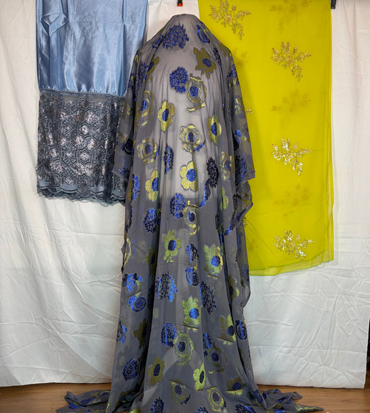 Floral-patterned fabric draped over a surface with other fabrics in the background.