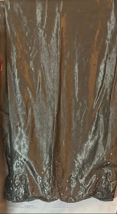 Silver sequin Somali Gorogarad fabric on a wooden surface