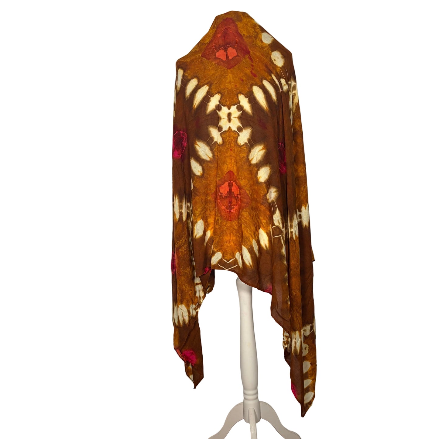 Brown patterned shawl on a white stand against a white backdrop