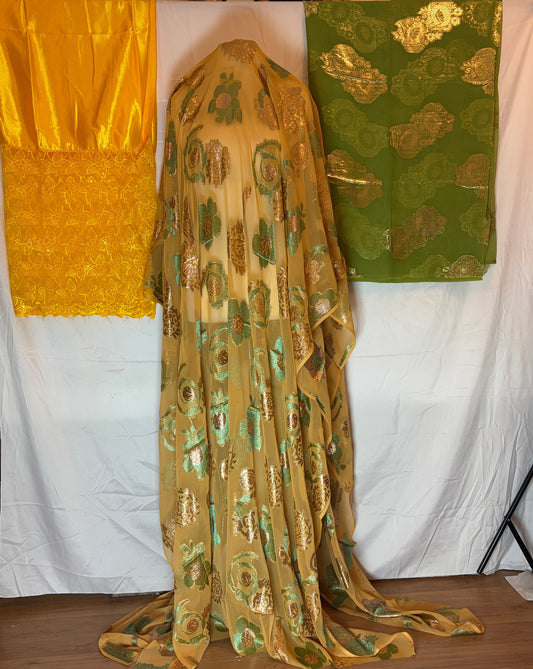 Gold and green patterned fabric on a white surface