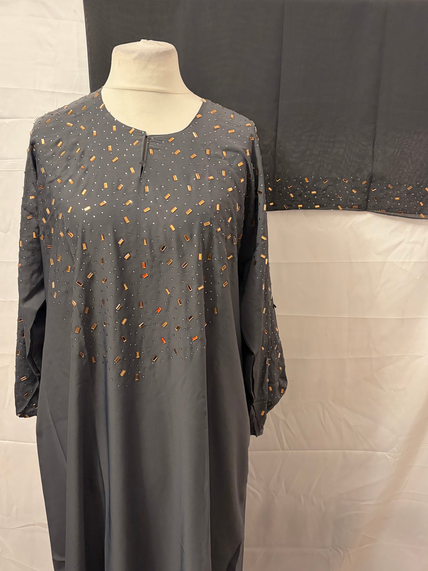 Gray dress with small pattern on a mannequin against a neutral background