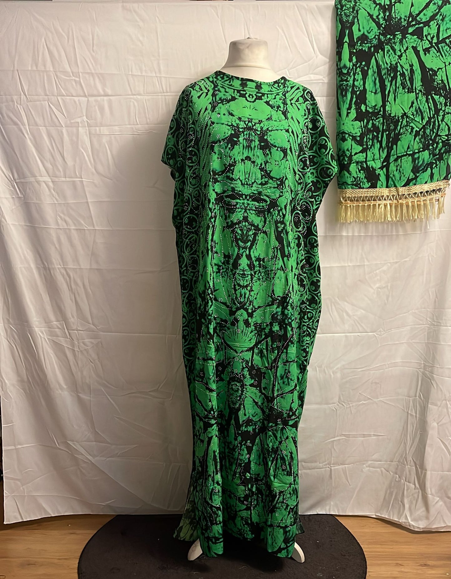 Green patterned Somali Baati on a mannequin against a white backdrop
