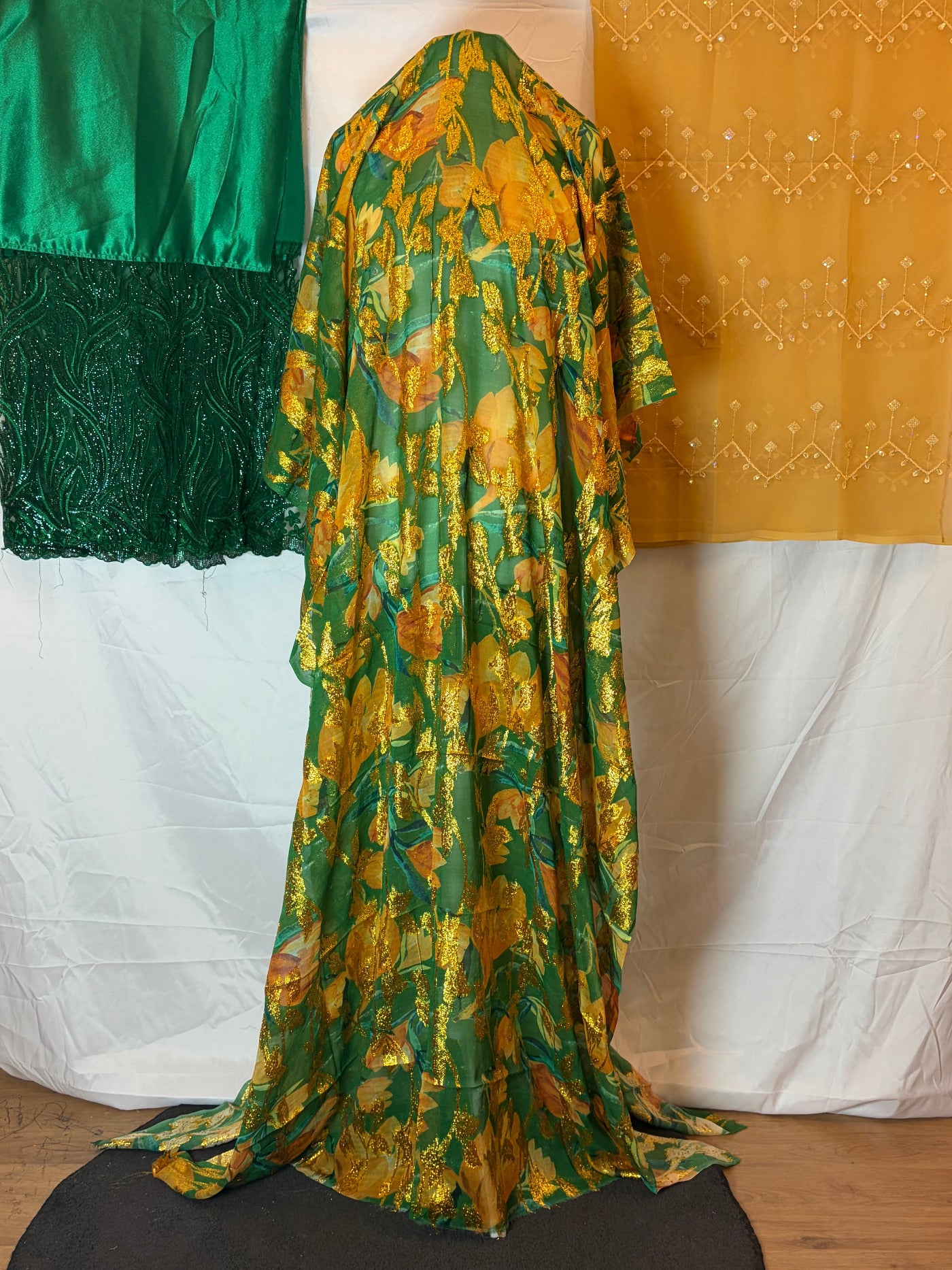 Green and gold patterned Dirac fabric on a white surface