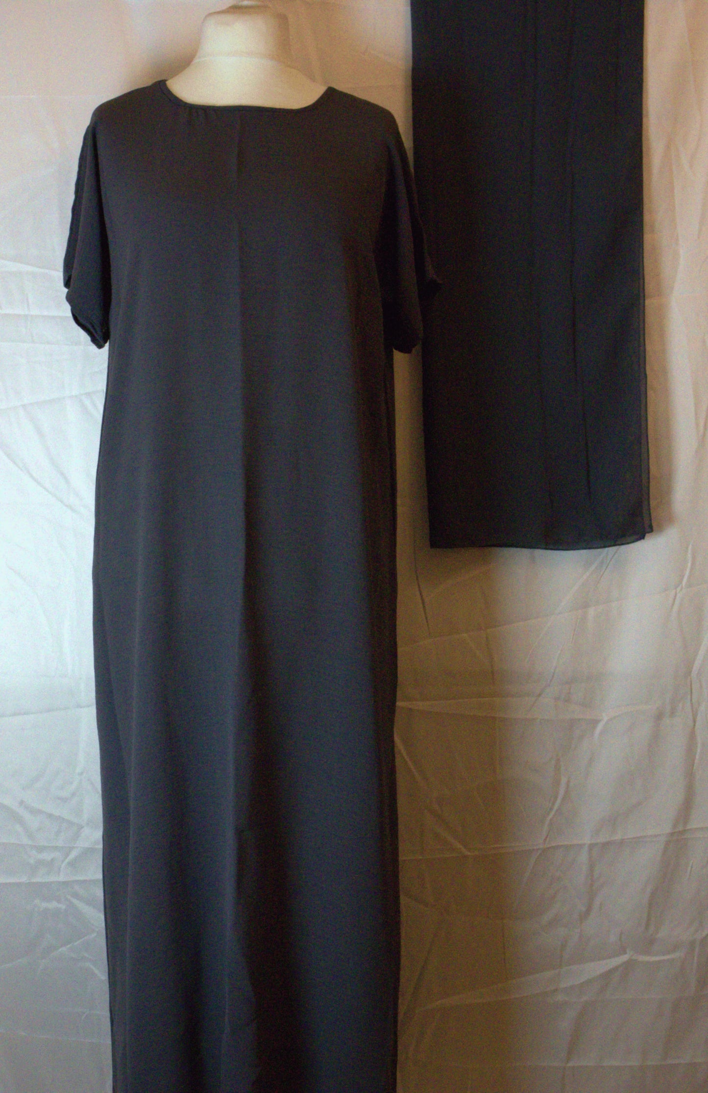 Long dark gray Abaya inside piece on a mannequin against a neutral background