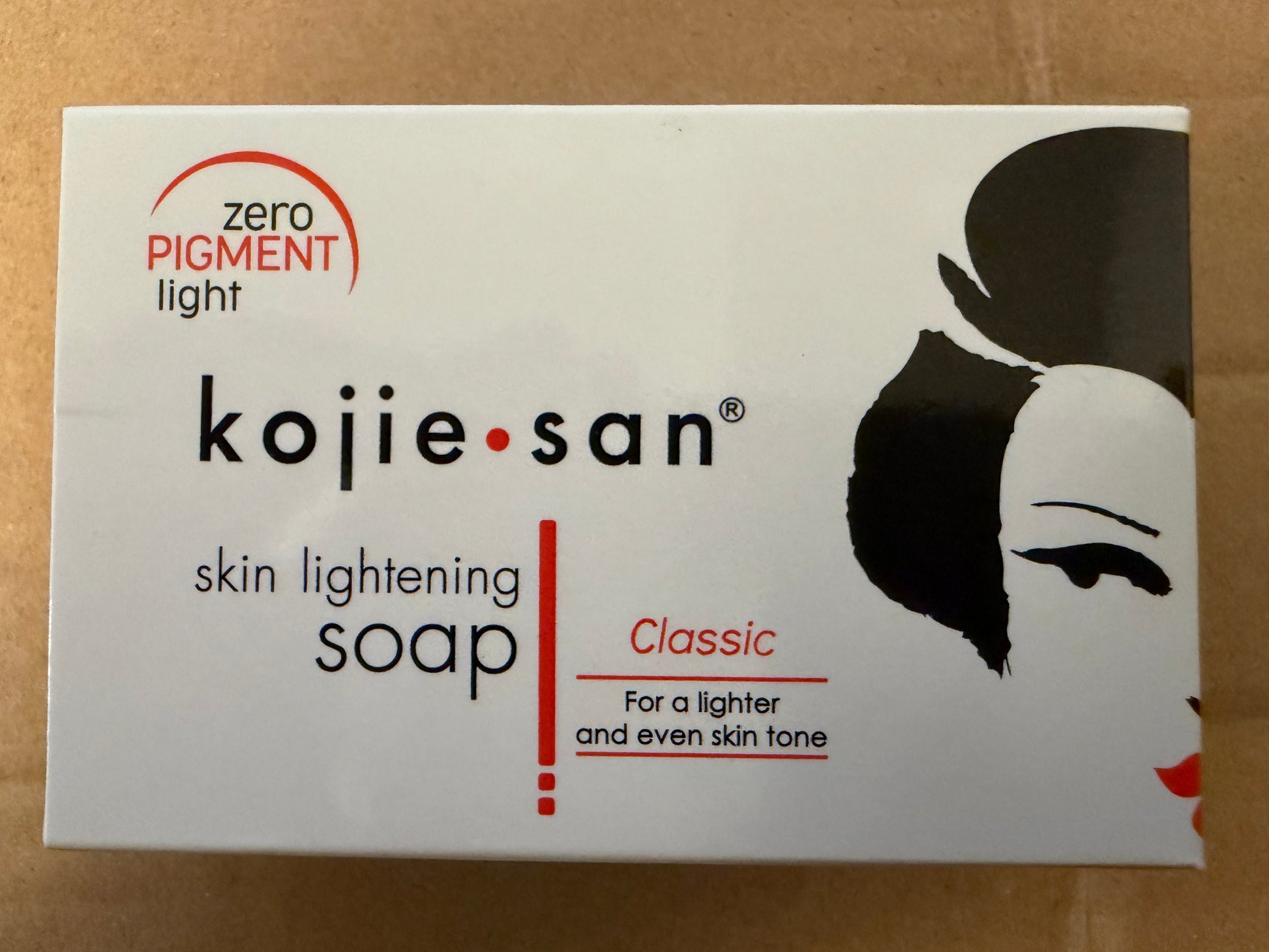 Kojie San skin lightening soap packaging on a brown background