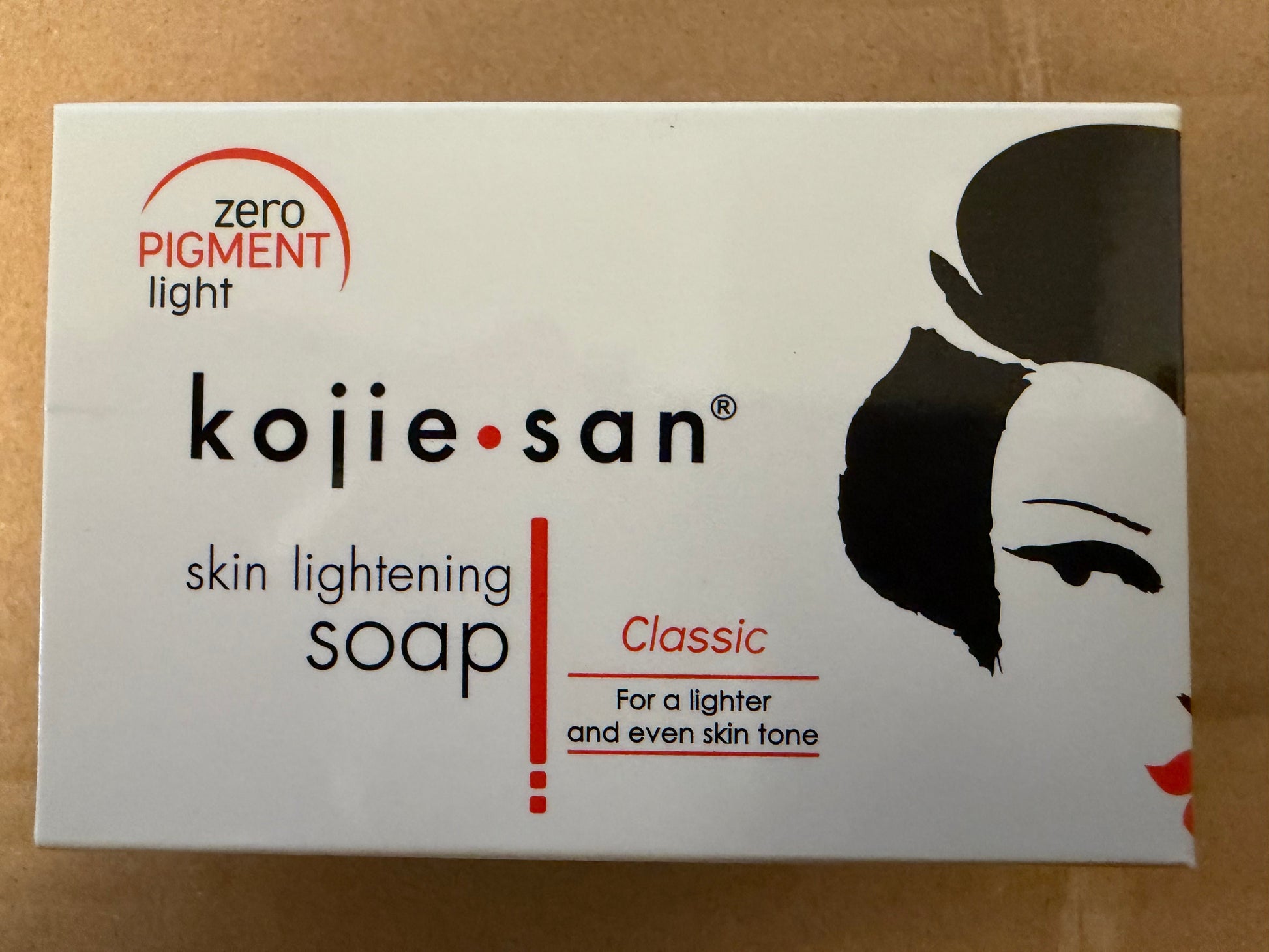 Kojie San skin lightening soap packaging on a brown background