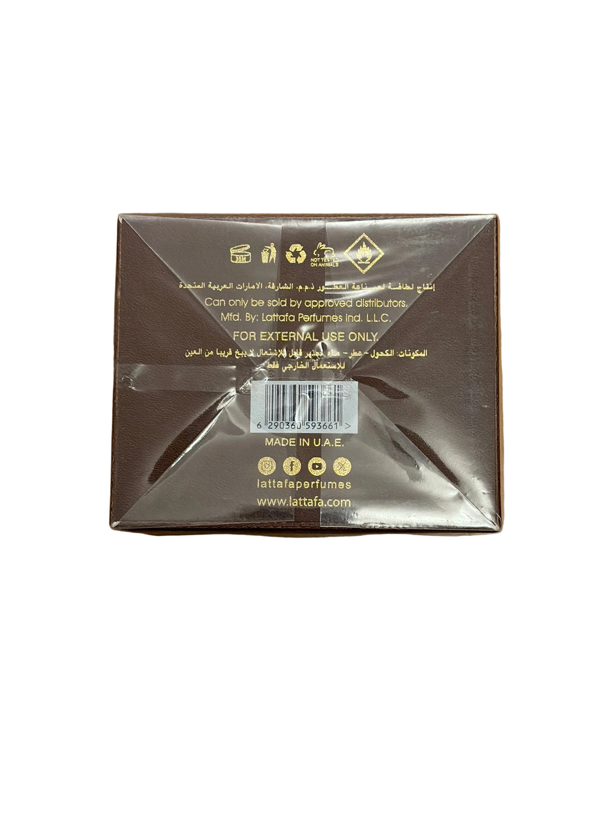The back of a square cardboard box for Lattafa Coffe Beans, wrapped in clear plastic, placed on a wooden surface. The box is dark brown with gold text and barcodes, and the Lattafa brand name is visible at the bottom.