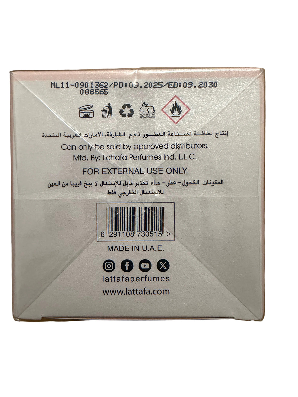 The back of a Lattafa perfume box on a wooden surface, showing product code ML11-0901352, manufacturing details in English and Arabic, a barcode, and social media handles.