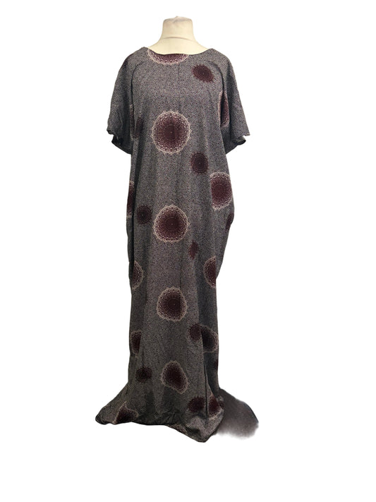 Long gray with burgundy dress with brown circular patterns on a mannequin against a white backdrop.