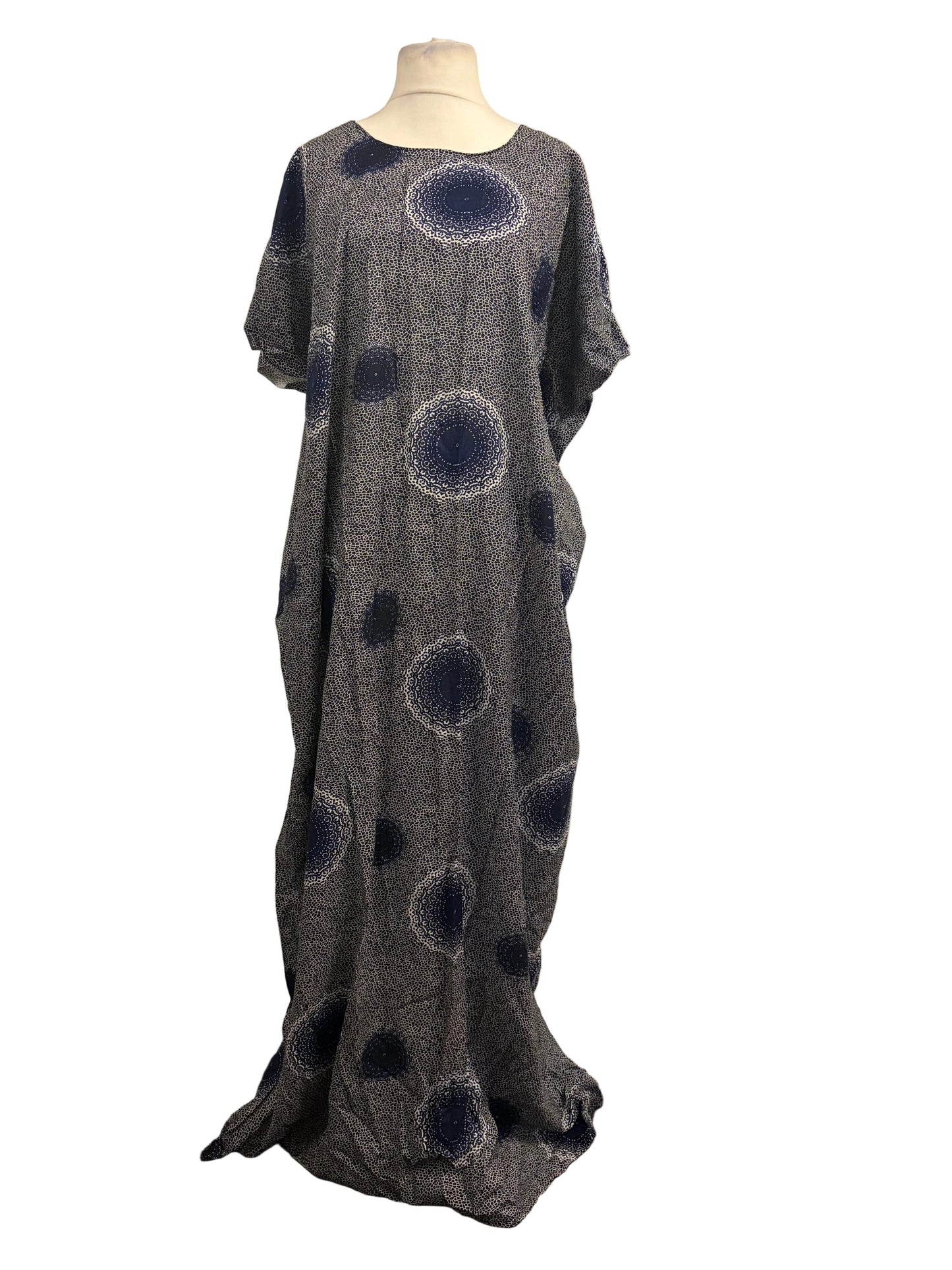 Gray dress with blue circular patterns on a mannequin against a white backdrop.