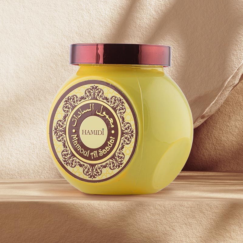 Yellow jar with decorative label and red lid on a beige background