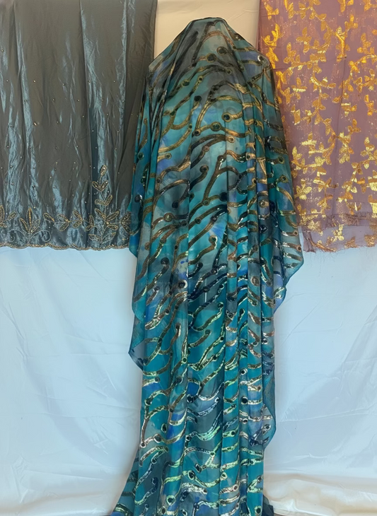 Blue patterned Somali Dirac fabric draped over a white surface with a colorful background