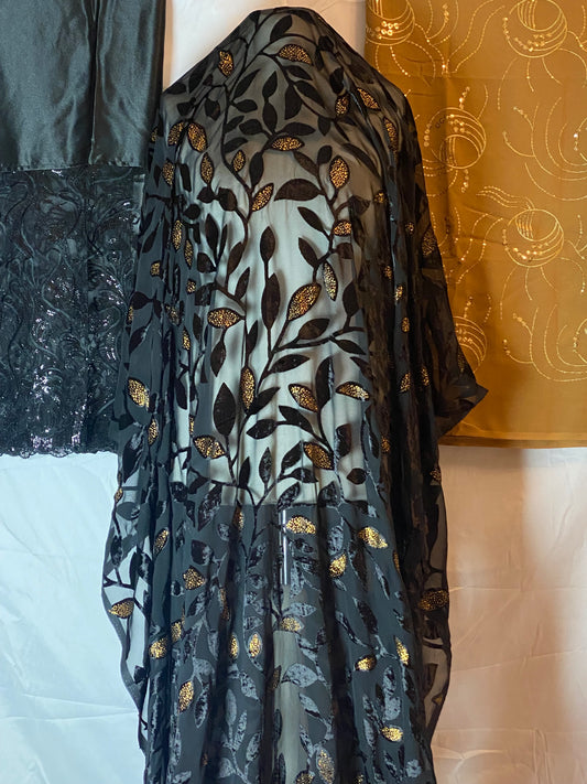 Maqbal dirac Black fabric with gold embroidery on a white surface