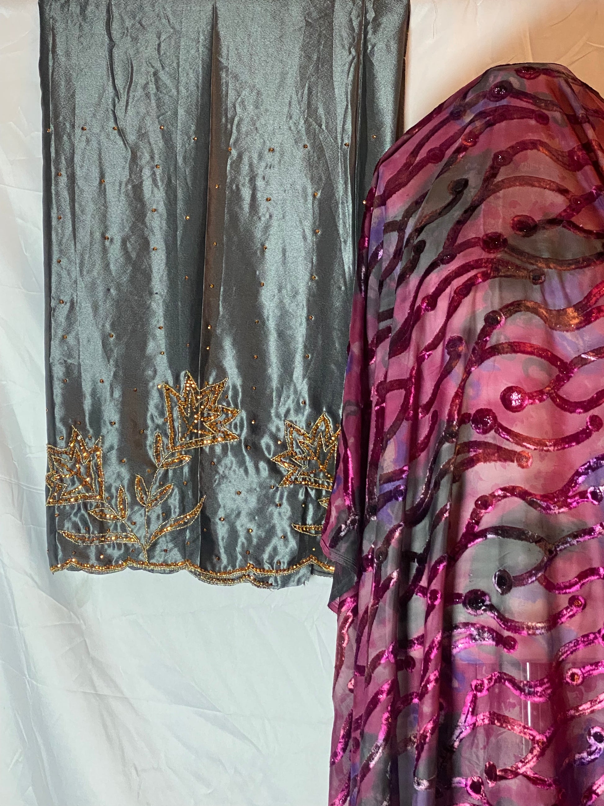 Maqbal dirac fabric with pink and purple patterns and a sword on a white background