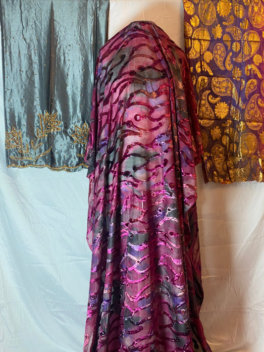 Maqbal dirac Close-up of patterned fabric with gold, purple, and black design on a white background