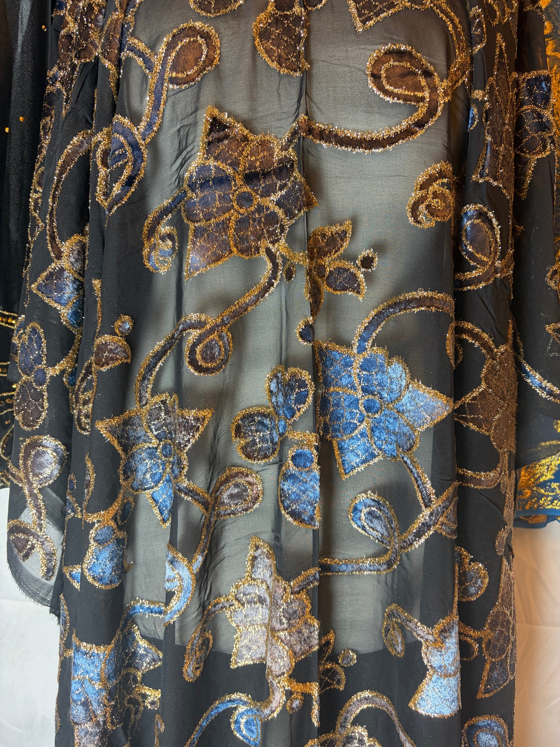Embroidered maqbal Dirac fabric with floral patterns in blue and gold on a black background