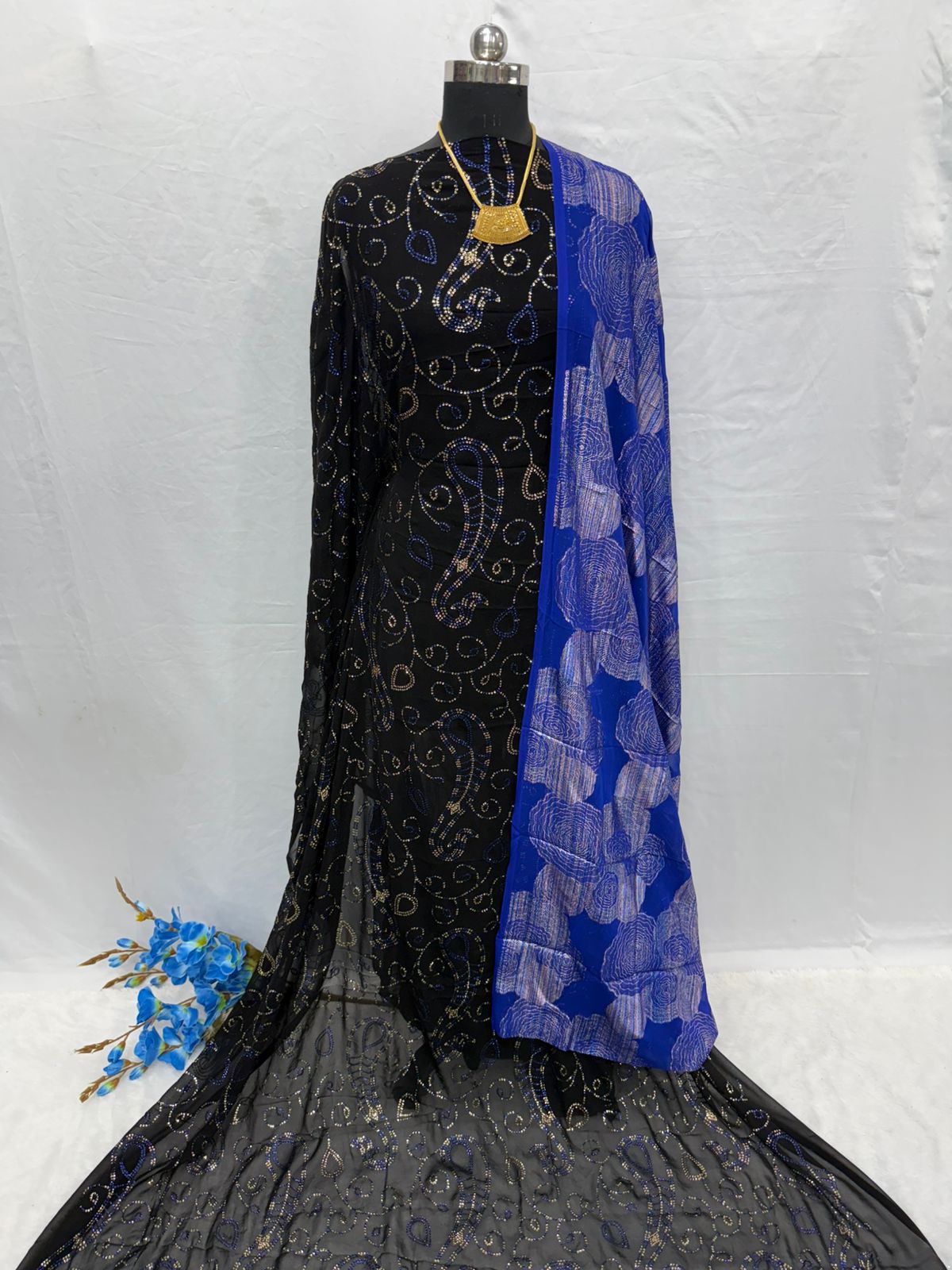 Mannequin wearing a black embroidered Maysa Somali Dirac with a blue patterned shawl on a white background