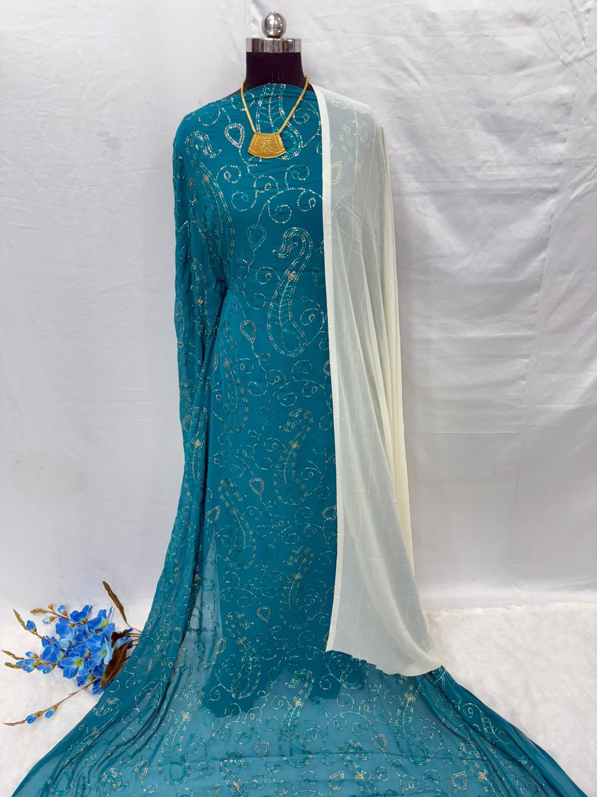 Teal embroidered Maysa Somali Dirac with white blouse on a mannequin against a white background