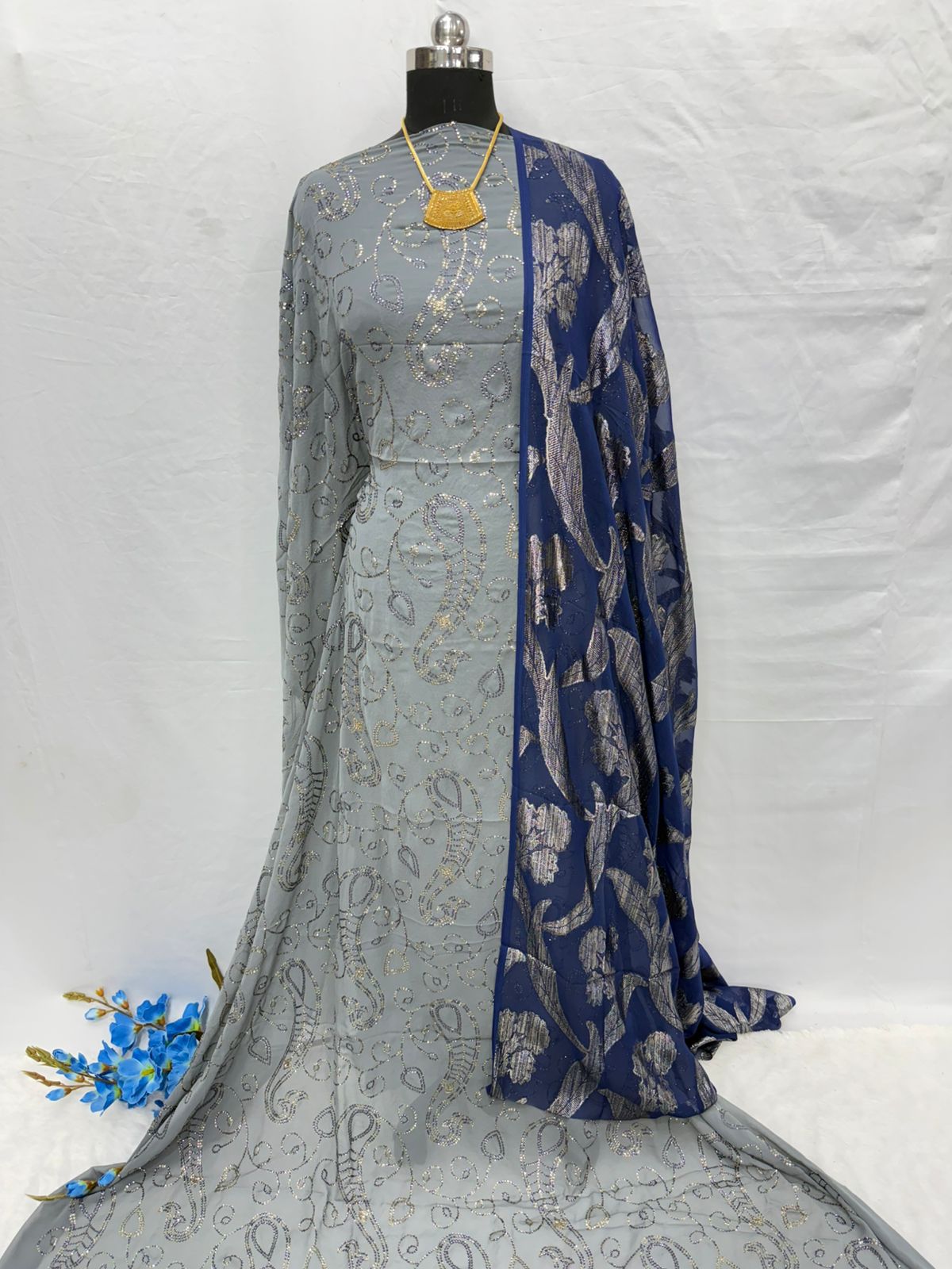 Gray and blue traditional Somali Dirac with a floral pattern on a white background