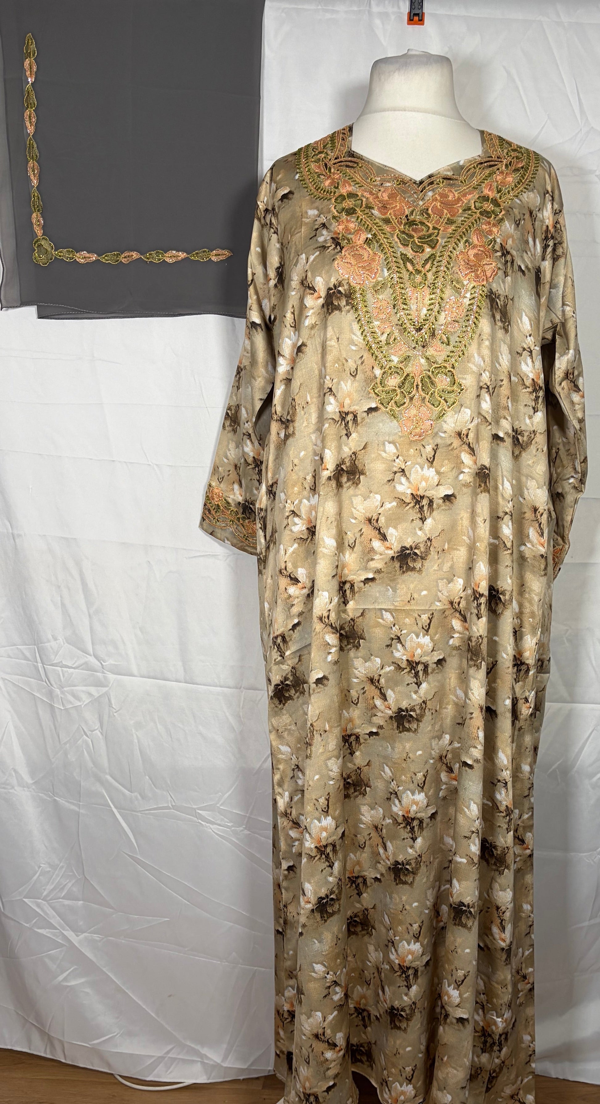 Mukawarar dress with floral patterns on a mannequin against a white background
