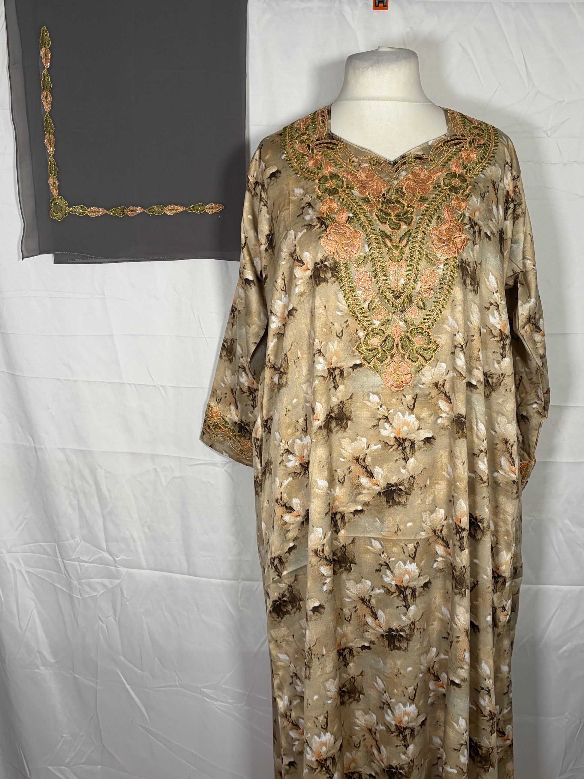 Floral embroidered Mukawarar dress on a mannequin against a white background