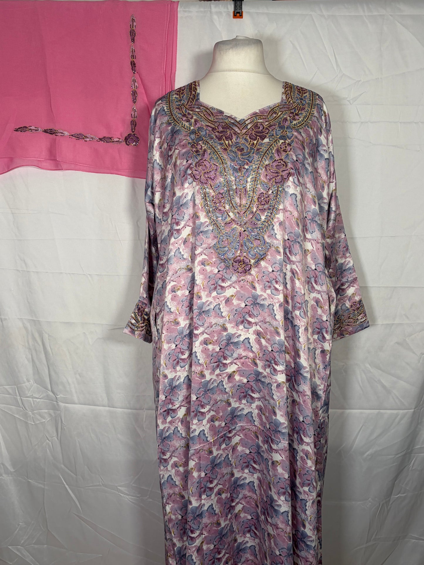 Floral patterned Mukawarar dress on a mannequin against a white background