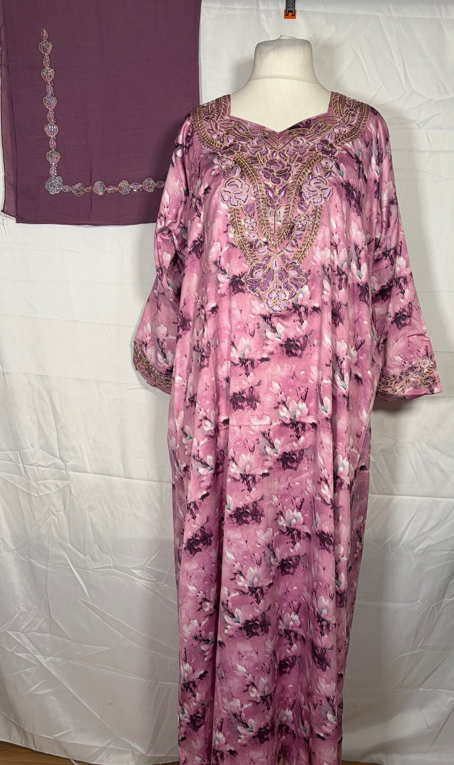 Purple floral Mukawarar dress on a mannequin against a white backdrop