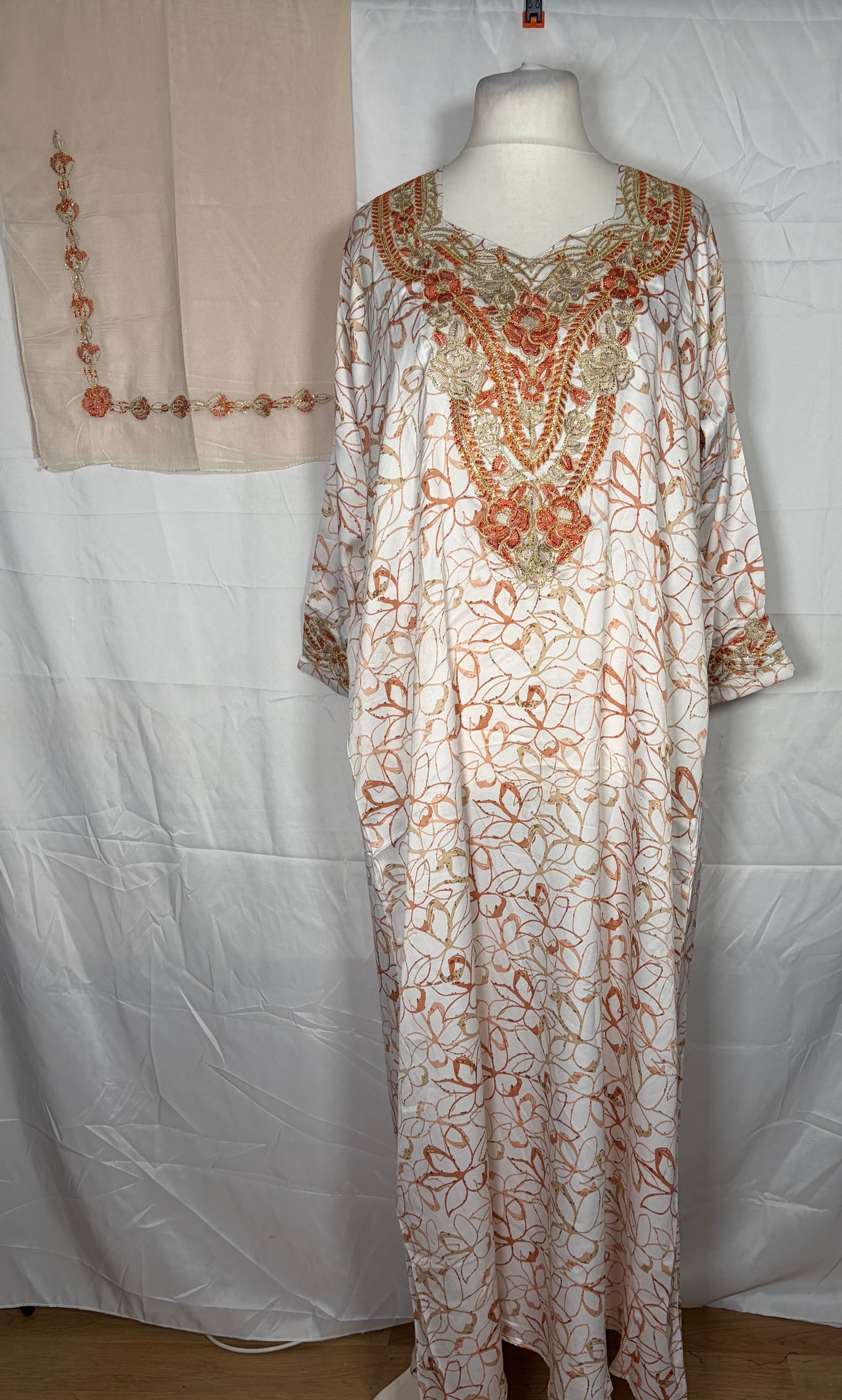 Long floral Mukawarar dress on a mannequin against a white background