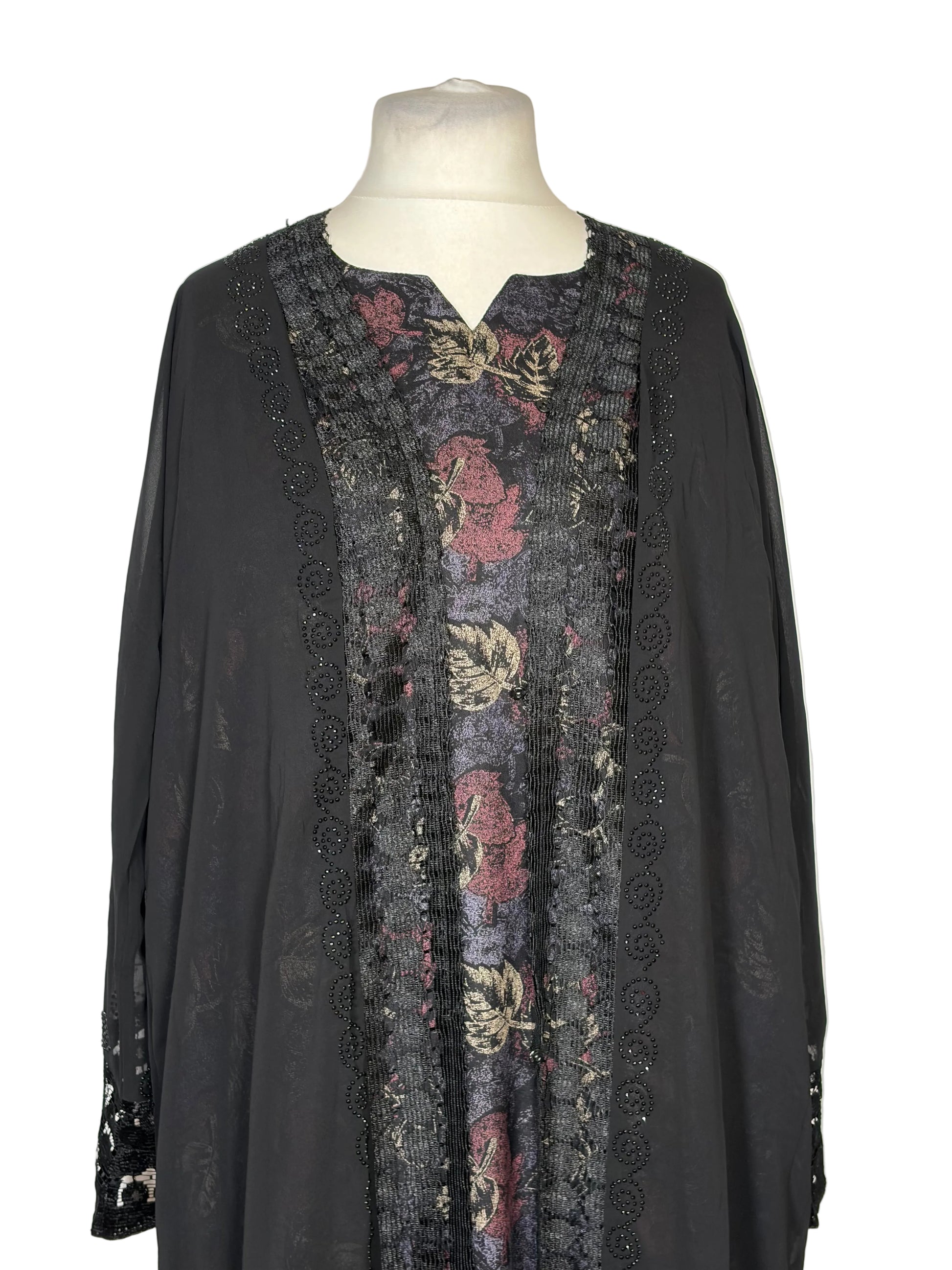 Black embroidered dress on a mannequin against a white background
