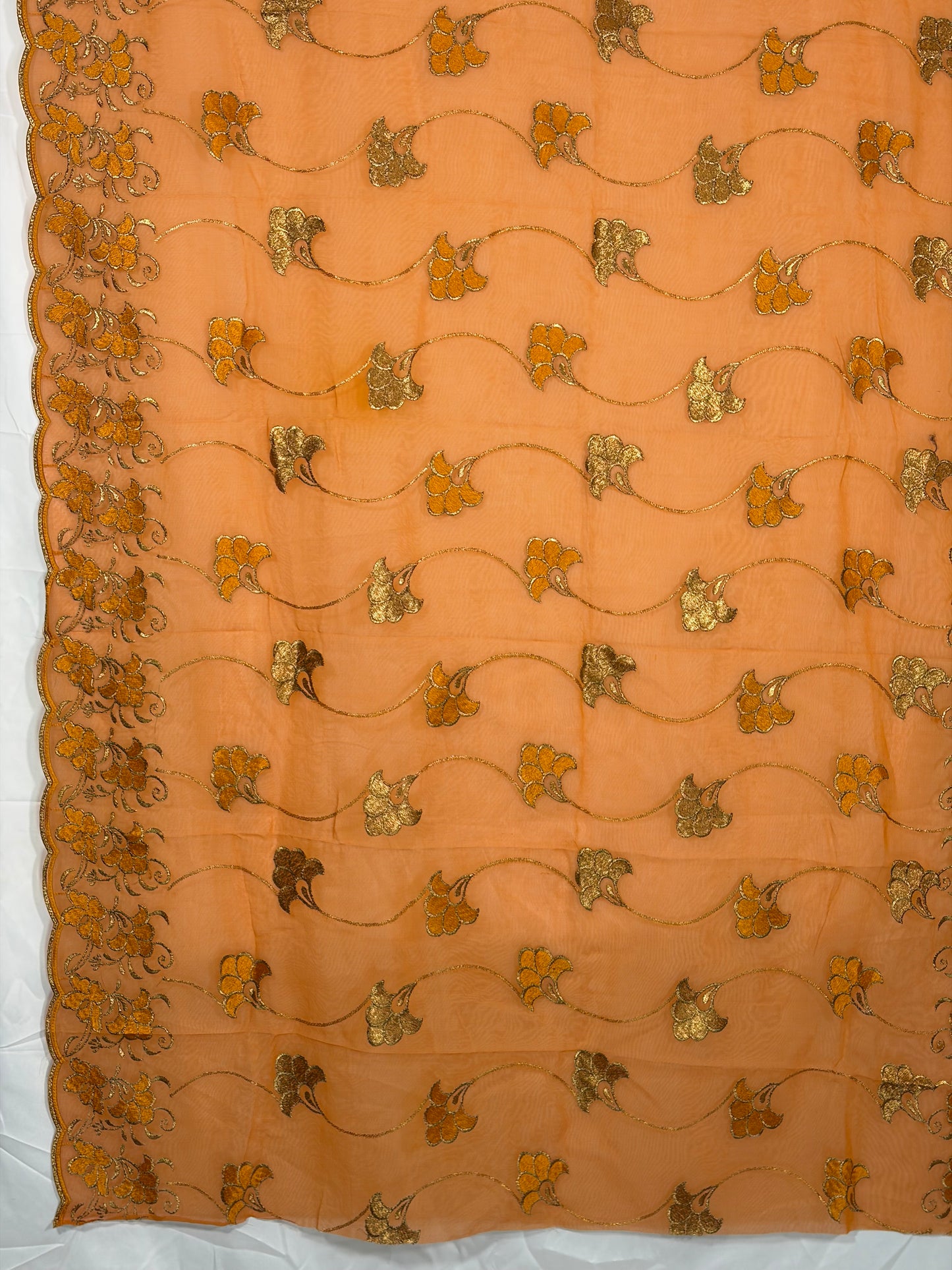Decorative fabric with gold floral patterns on a peach background