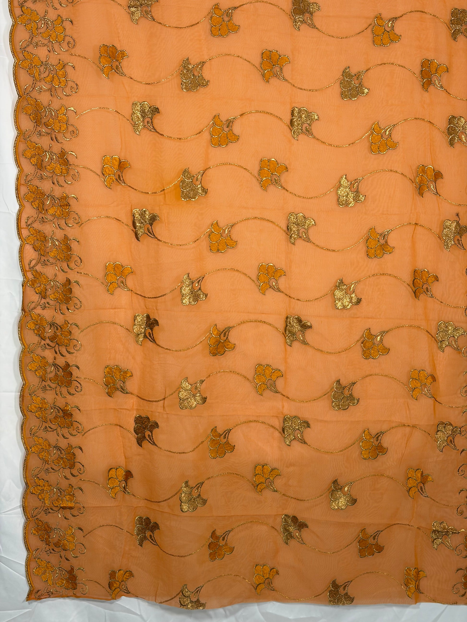 Decorative fabric with gold floral patterns on a peach background