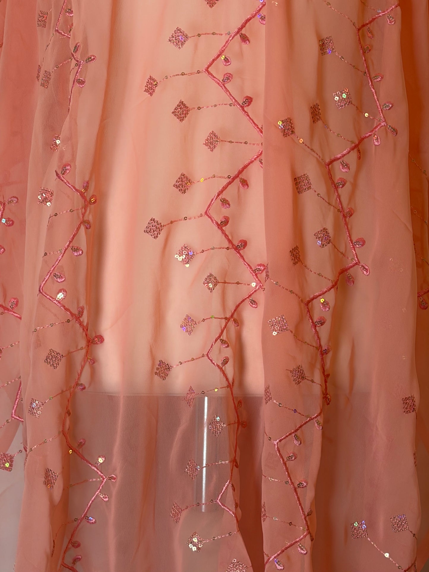 Peach orange Garbasaar fabric with floral bead embroidery on a plain background