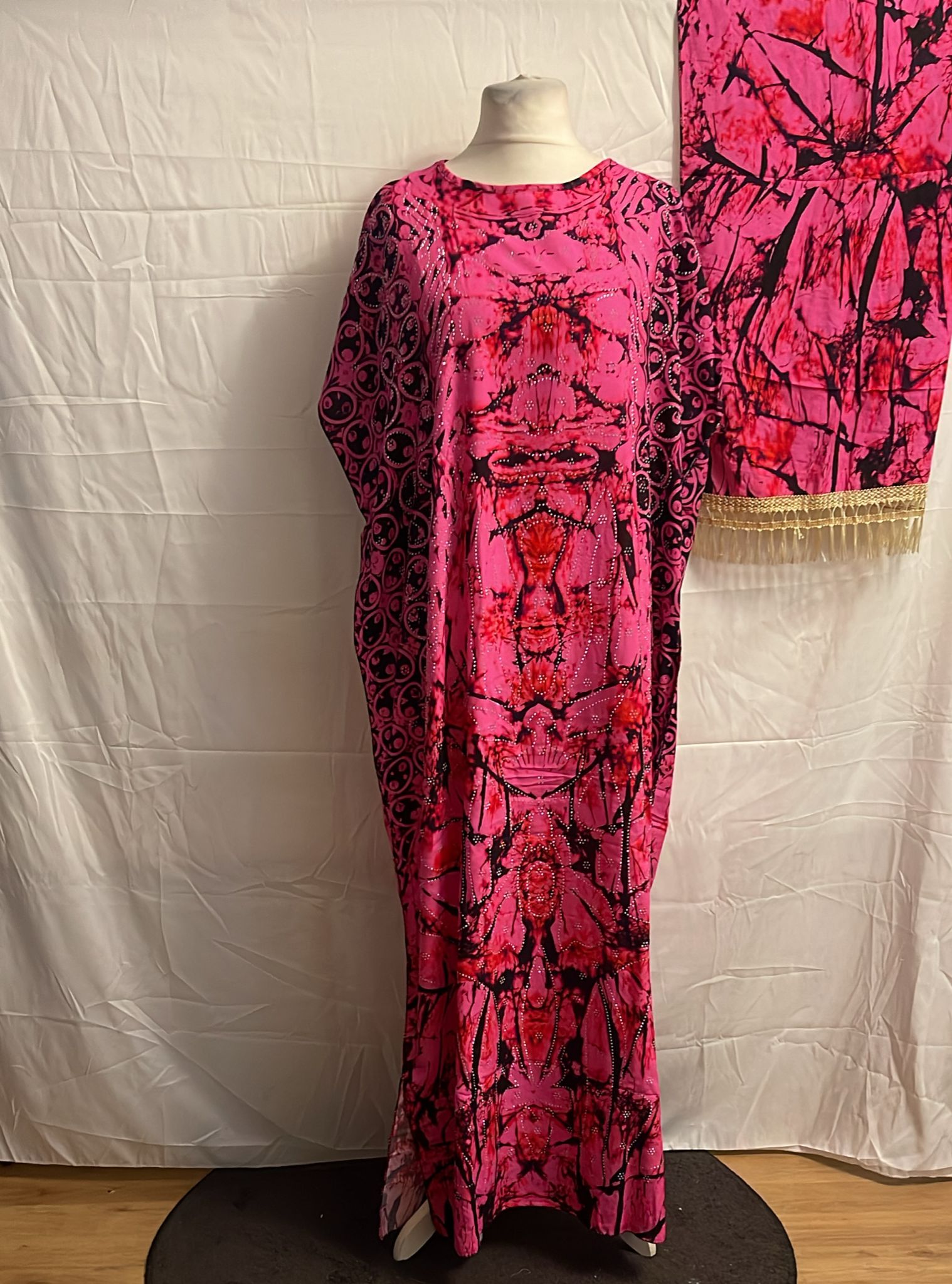 Pink and black patterned Somali Baati on a mannequin against a white backdrop