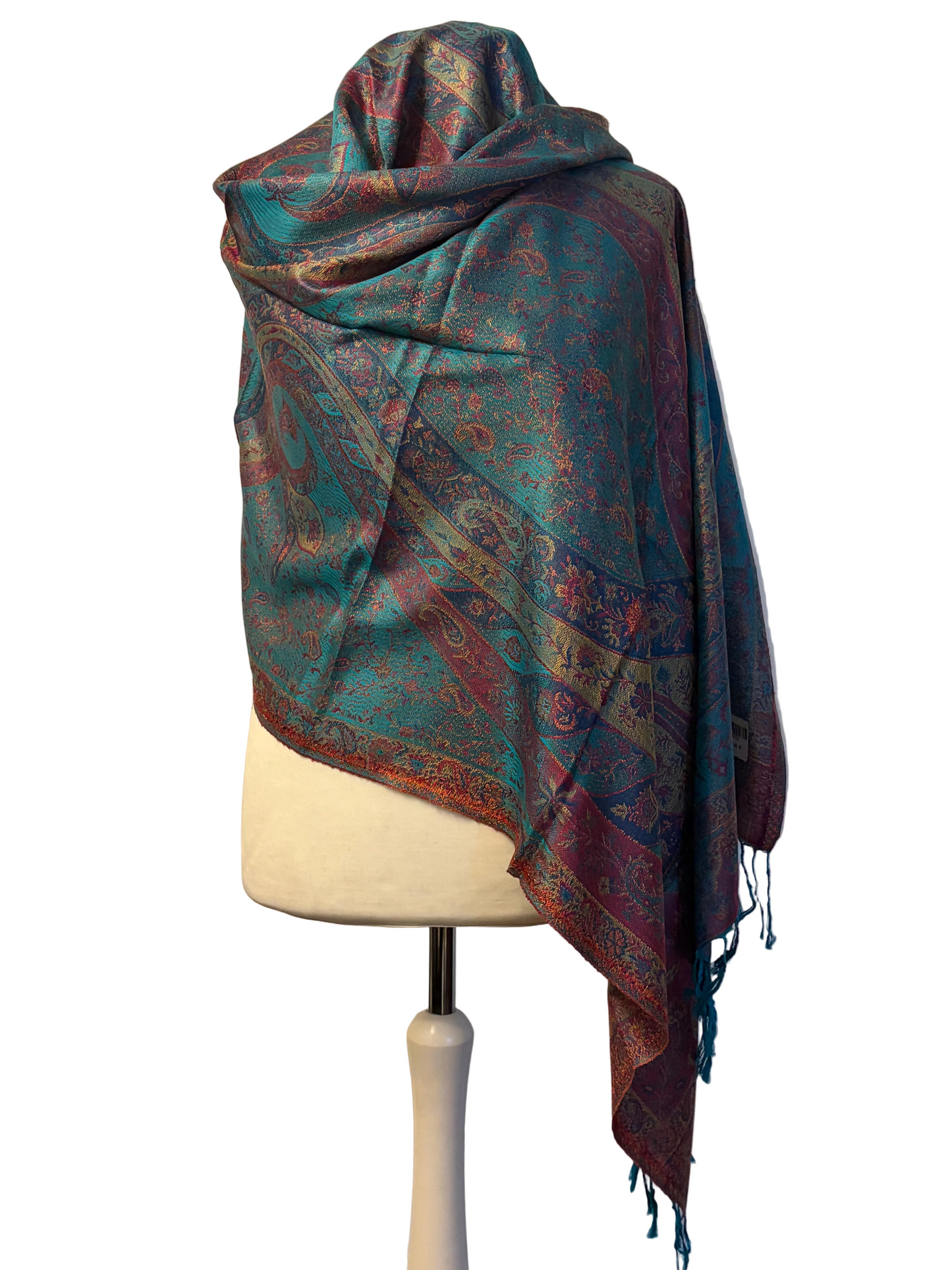 Patterned scarf draped over a mannequin against a textured white background