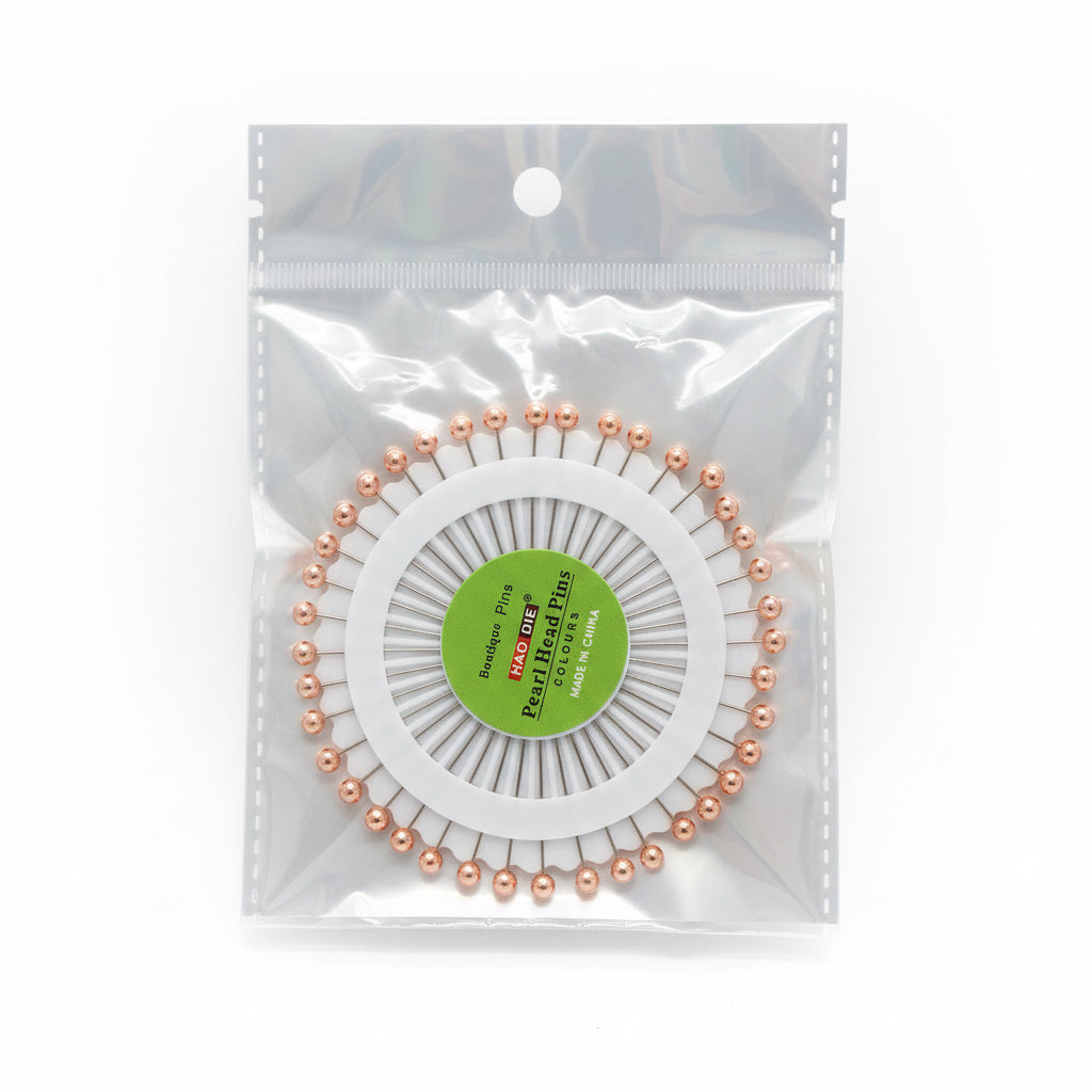 Pack of Hijab pins with a visible brand label on a wooden surface