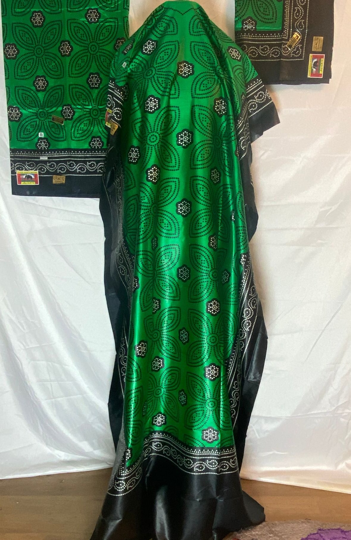 Green and black patterned Somali Shaash fabric draped over a white surface