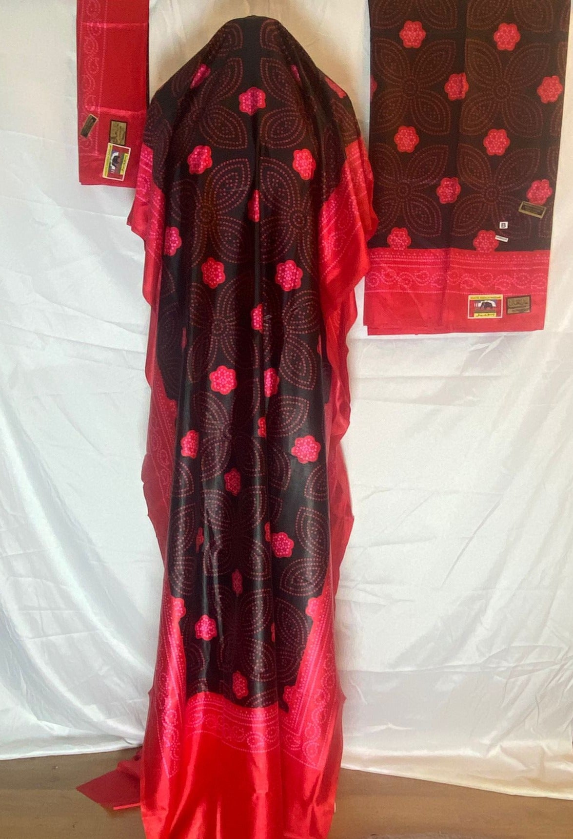 Red and black patterned Somali Shaash fabric with a matching bag on a white background