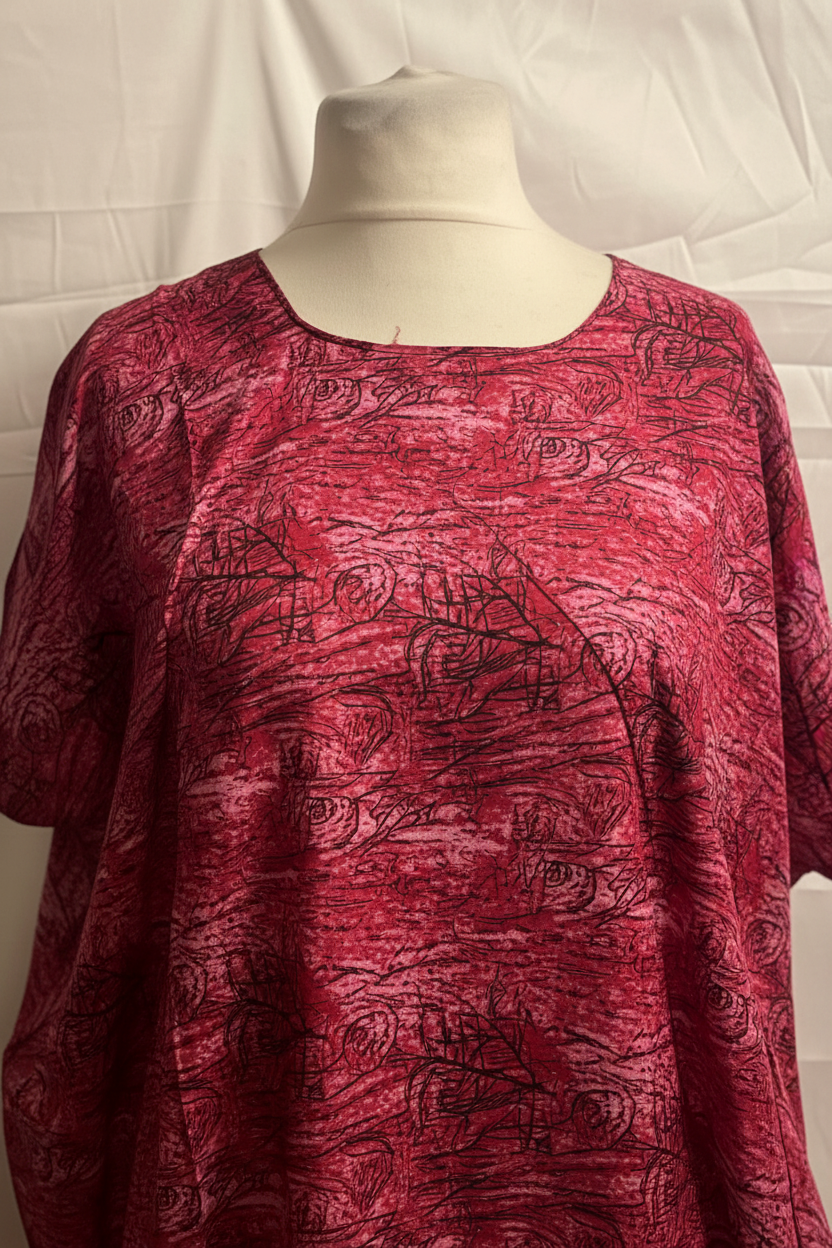 Red patterned Somali baati on a mannequin against a white background