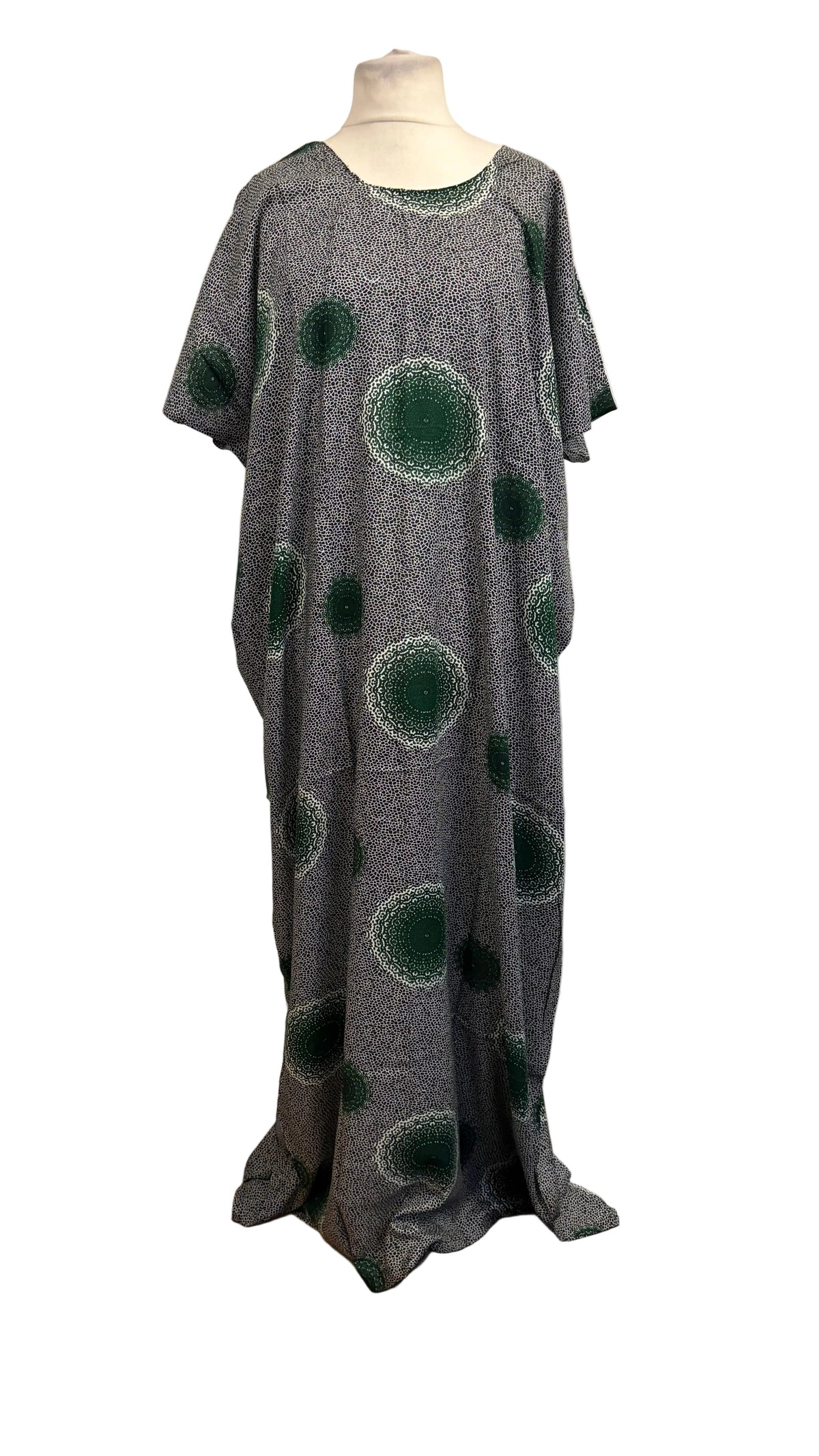 A gray Baati dress with green circular spot patterns displayed on a mannequin torso in front of a white fabric backdrop.