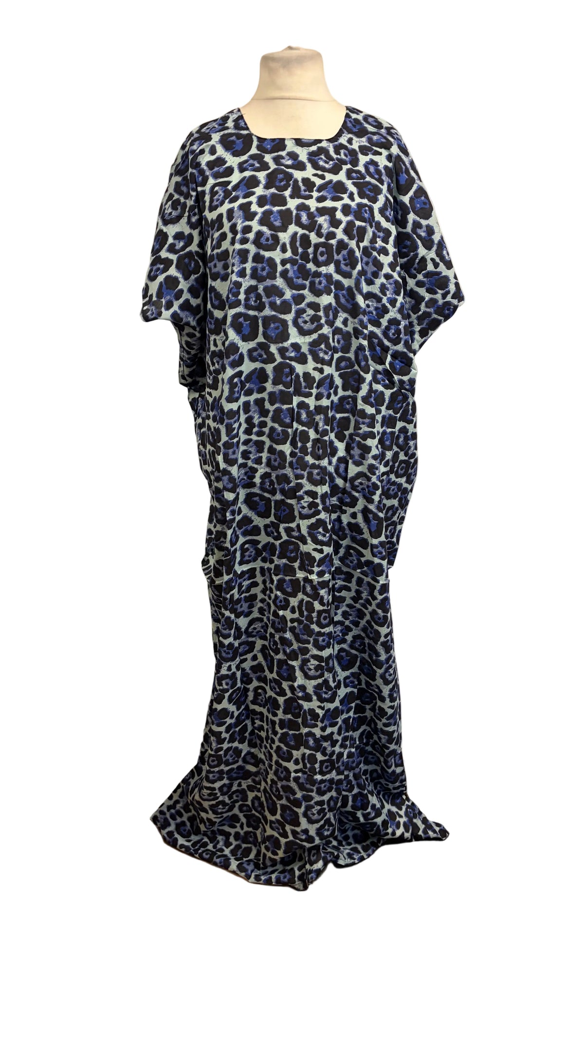 A floor-length blue and white leopard print Somali Baati displayed on a mannequin in front of a white fabric backdrop. 