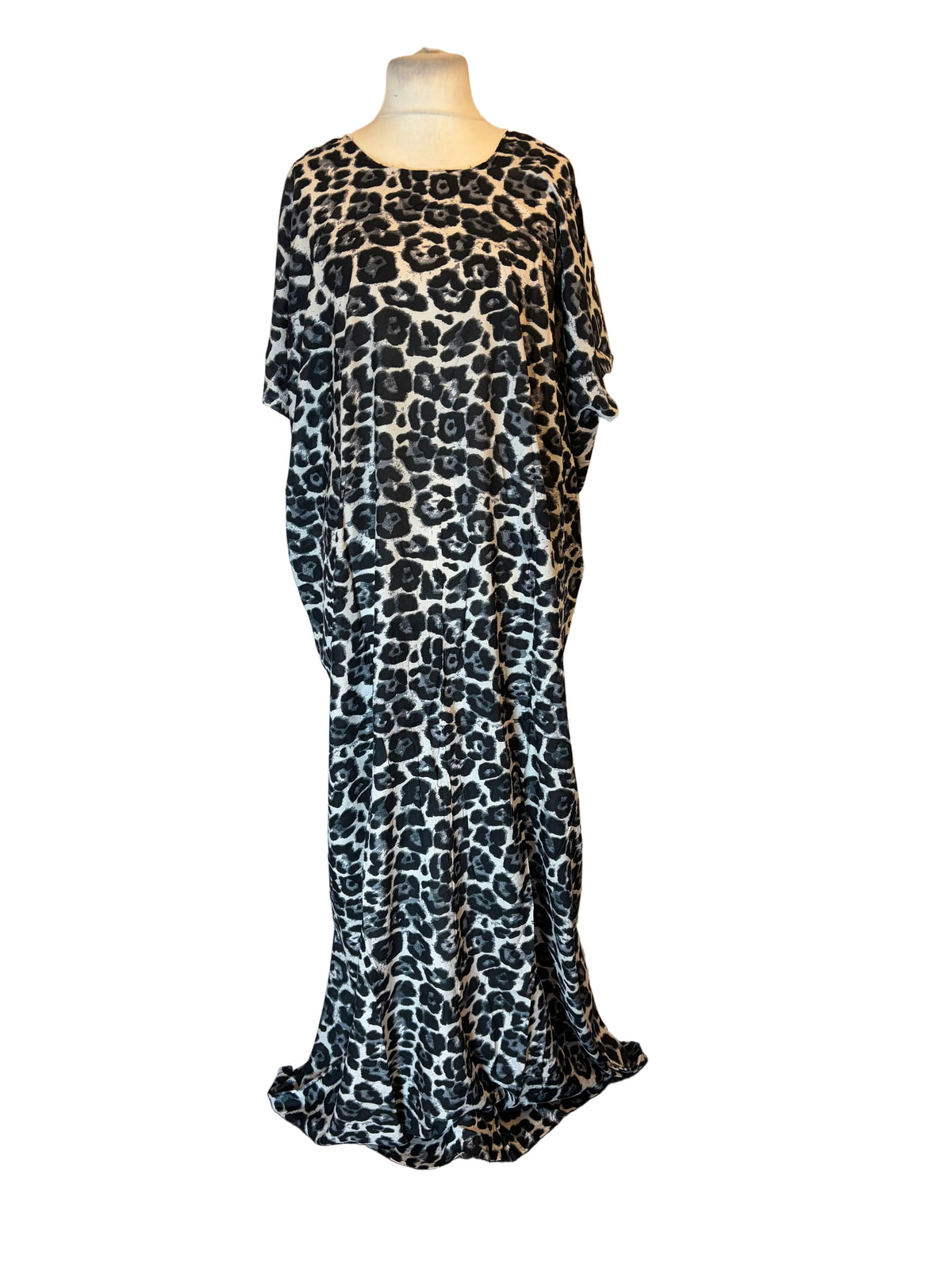 A long-sleeved Somali Baati dress with a black and white leopard print pattern, displayed on a mannequin in front of a white fabric backdrop.