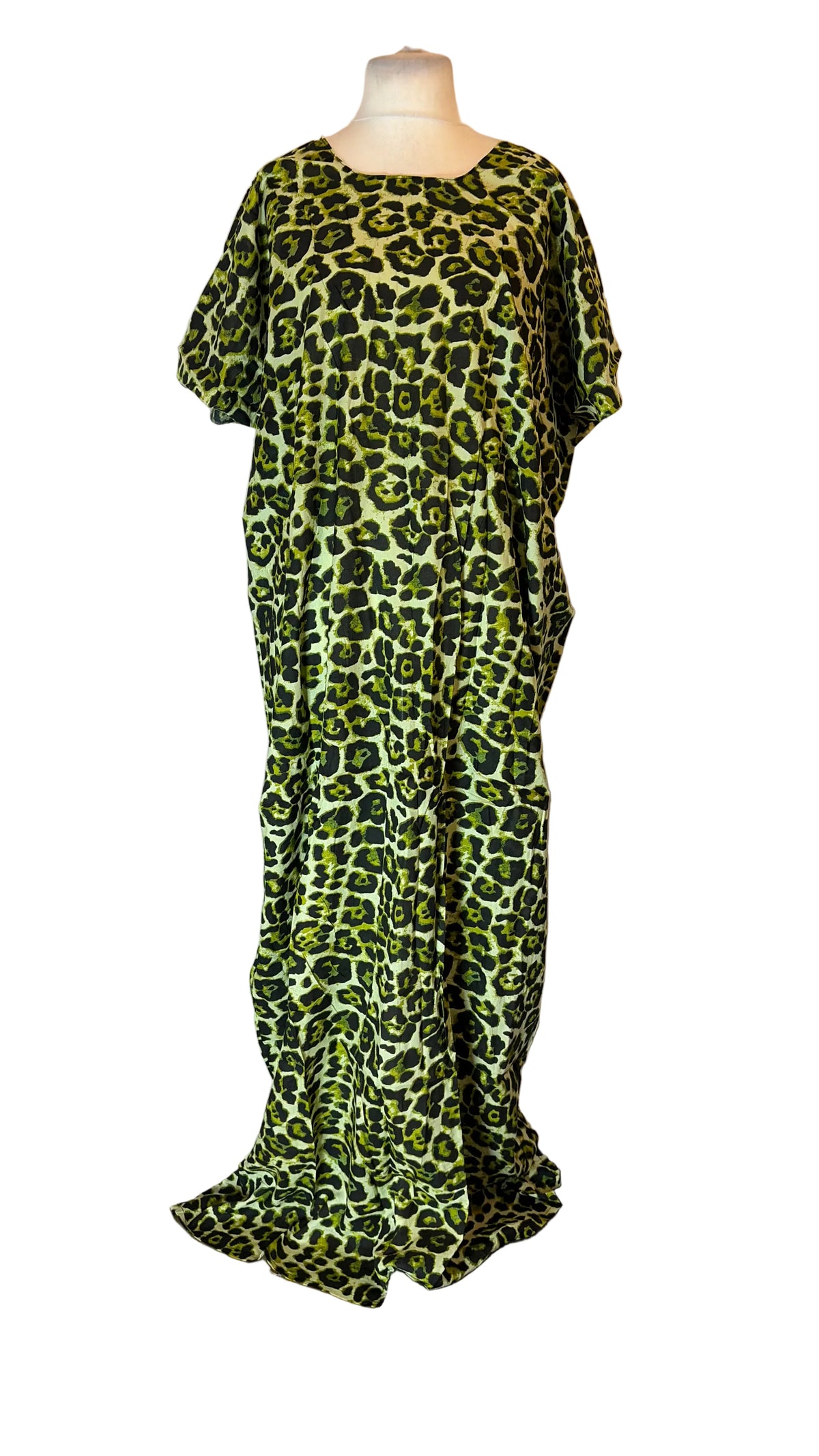 A short-sleeved Somali Baati with a green and black leopard print pattern, displayed on a mannequin in front of a white fabric backdrop.