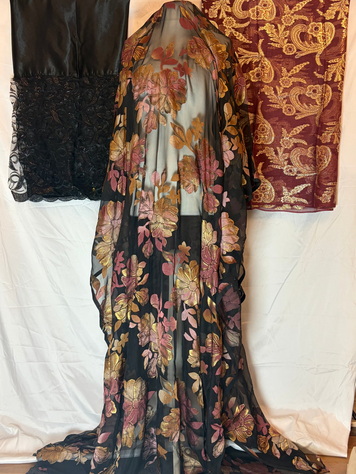 Floral patterned garment on a white background with a textured red fabric in the background.