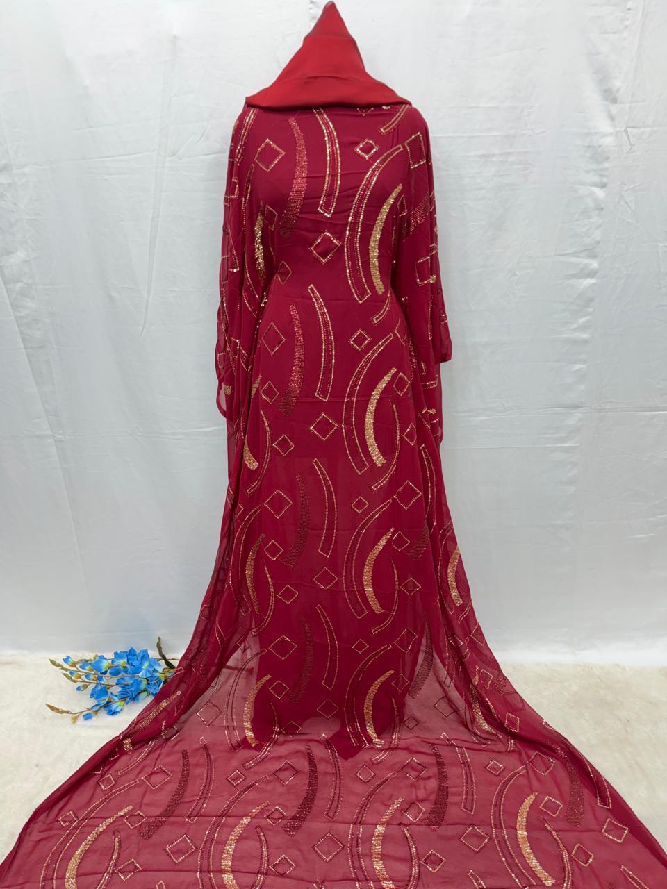 Red Maysa Somali Dirac fabric with gold patterns on a white background