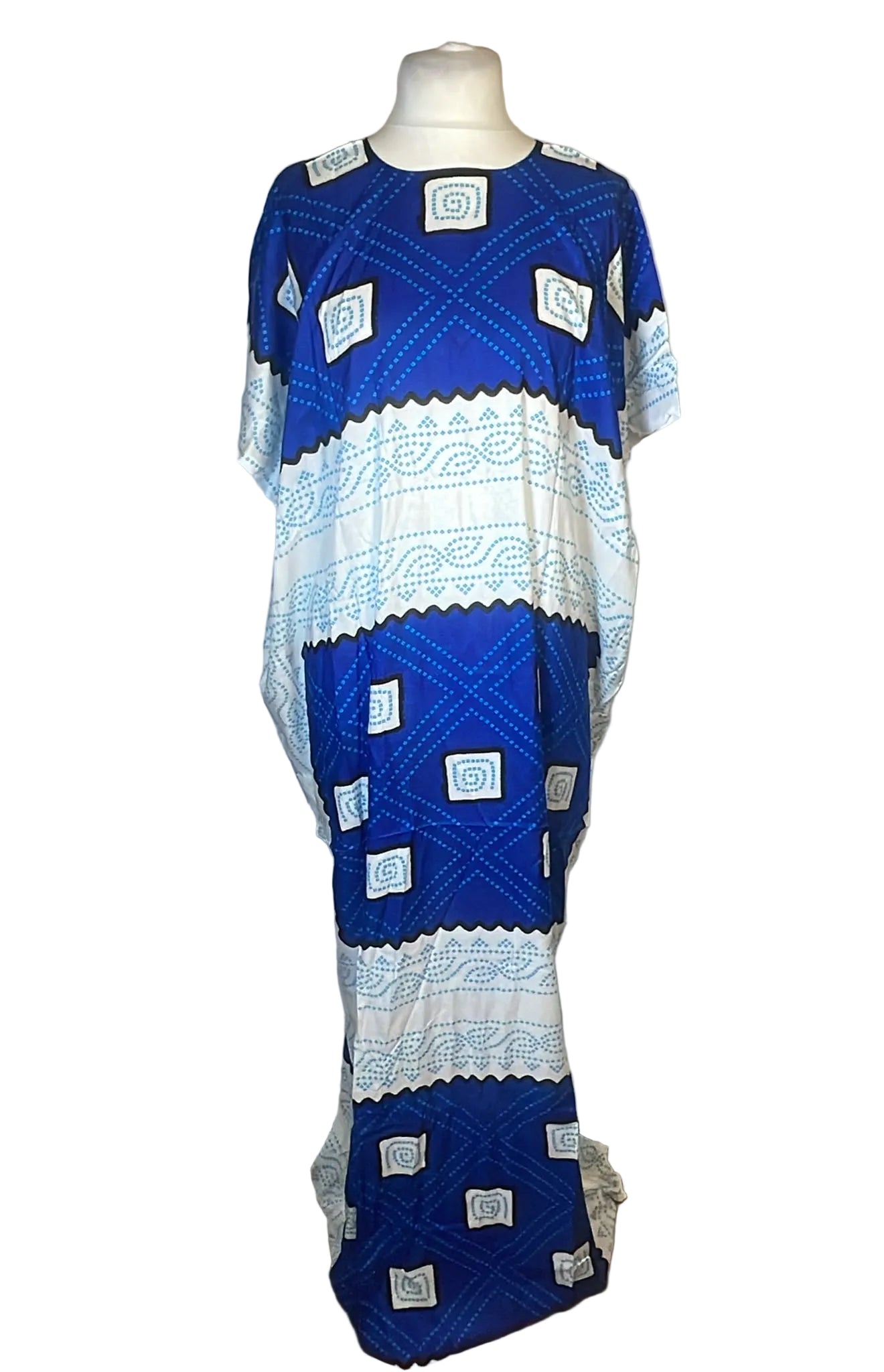 A blue and white patterned kaftan dress displayed on a mannequin against a white fabric backdrop.