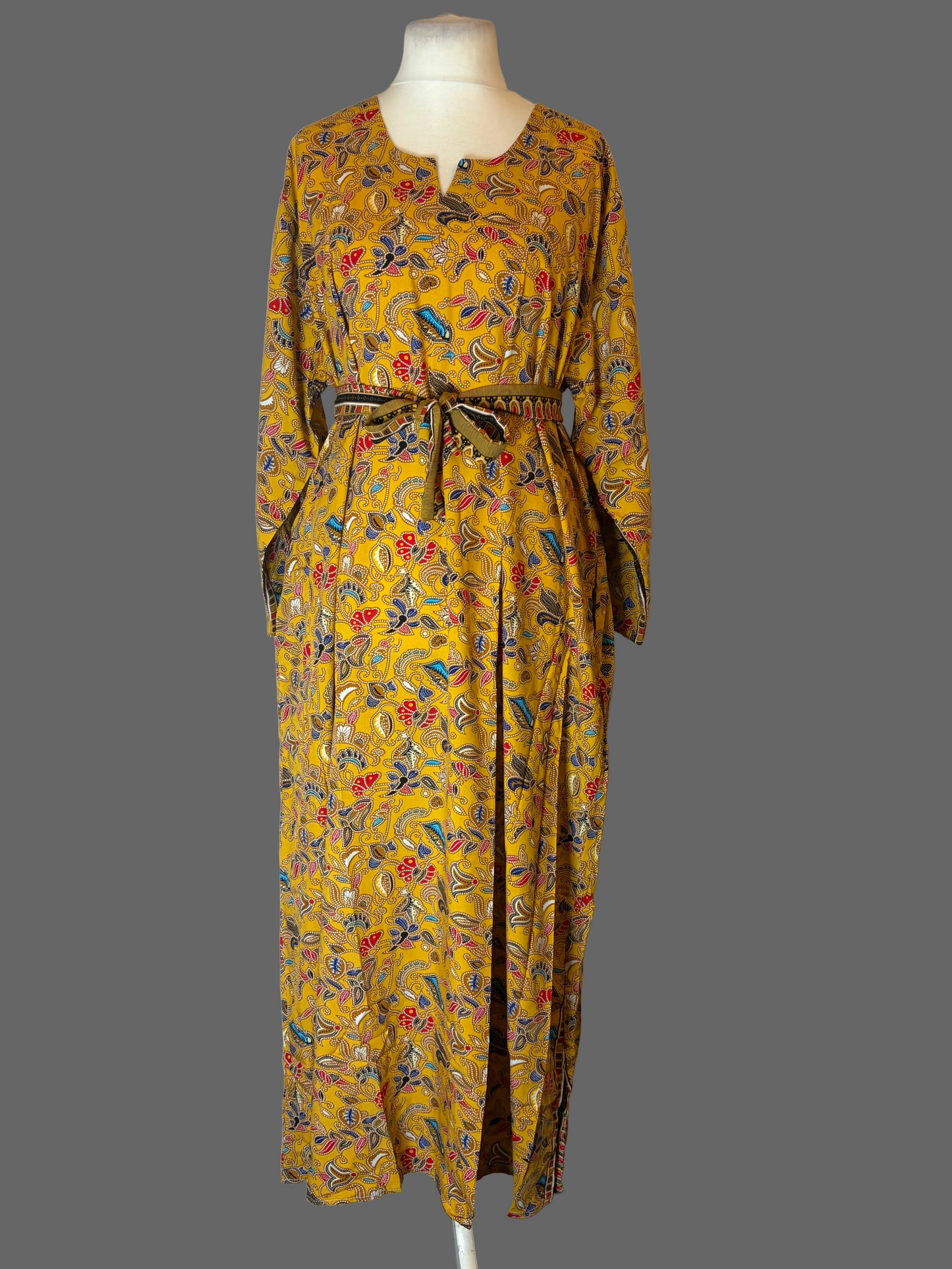 Yellow patterned dress on a mannequin against a white background