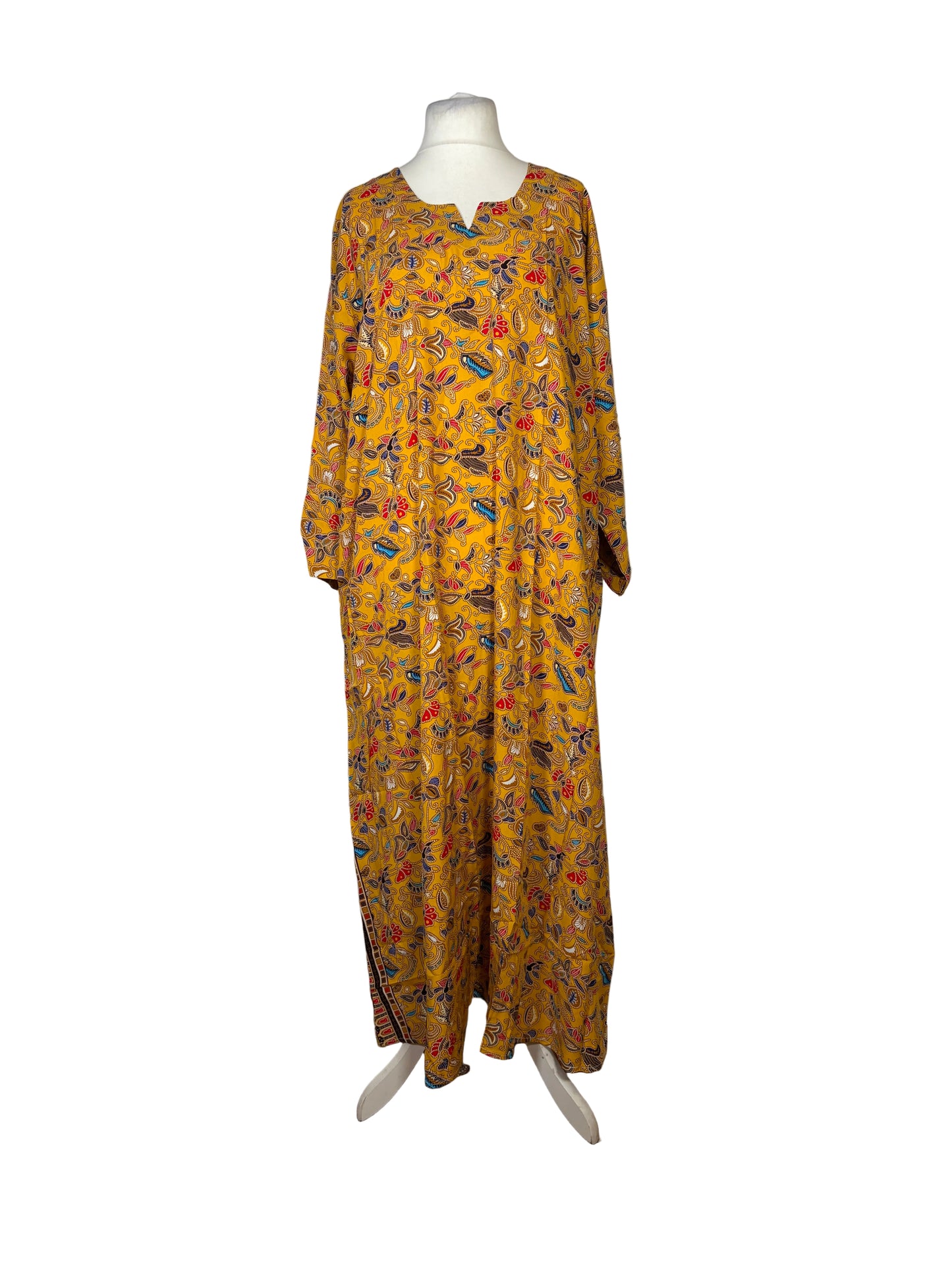 Yellow patterned dress on a mannequin against a white backdrop