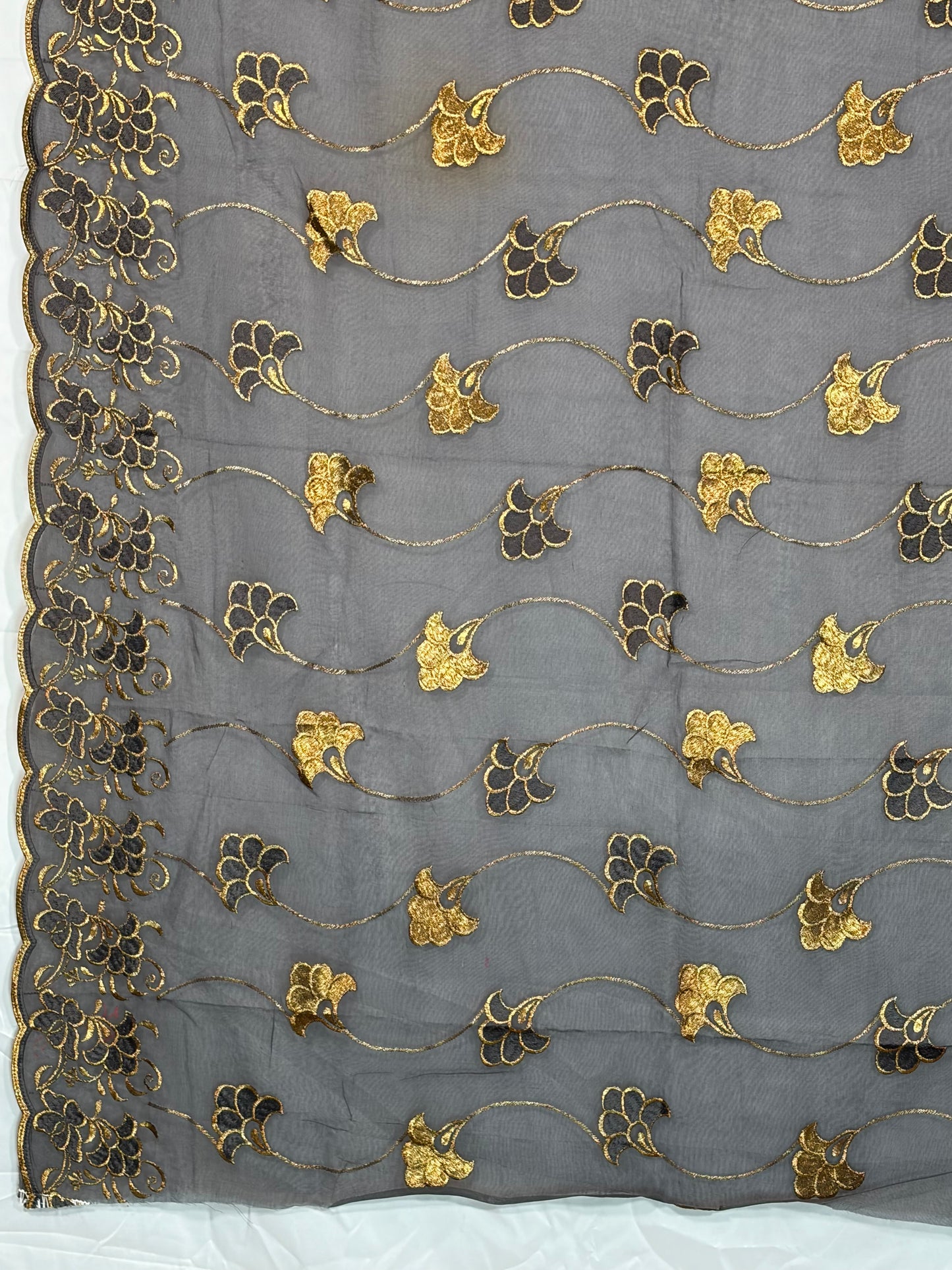Decorative fabric with gold and black floral patterns on a gray background