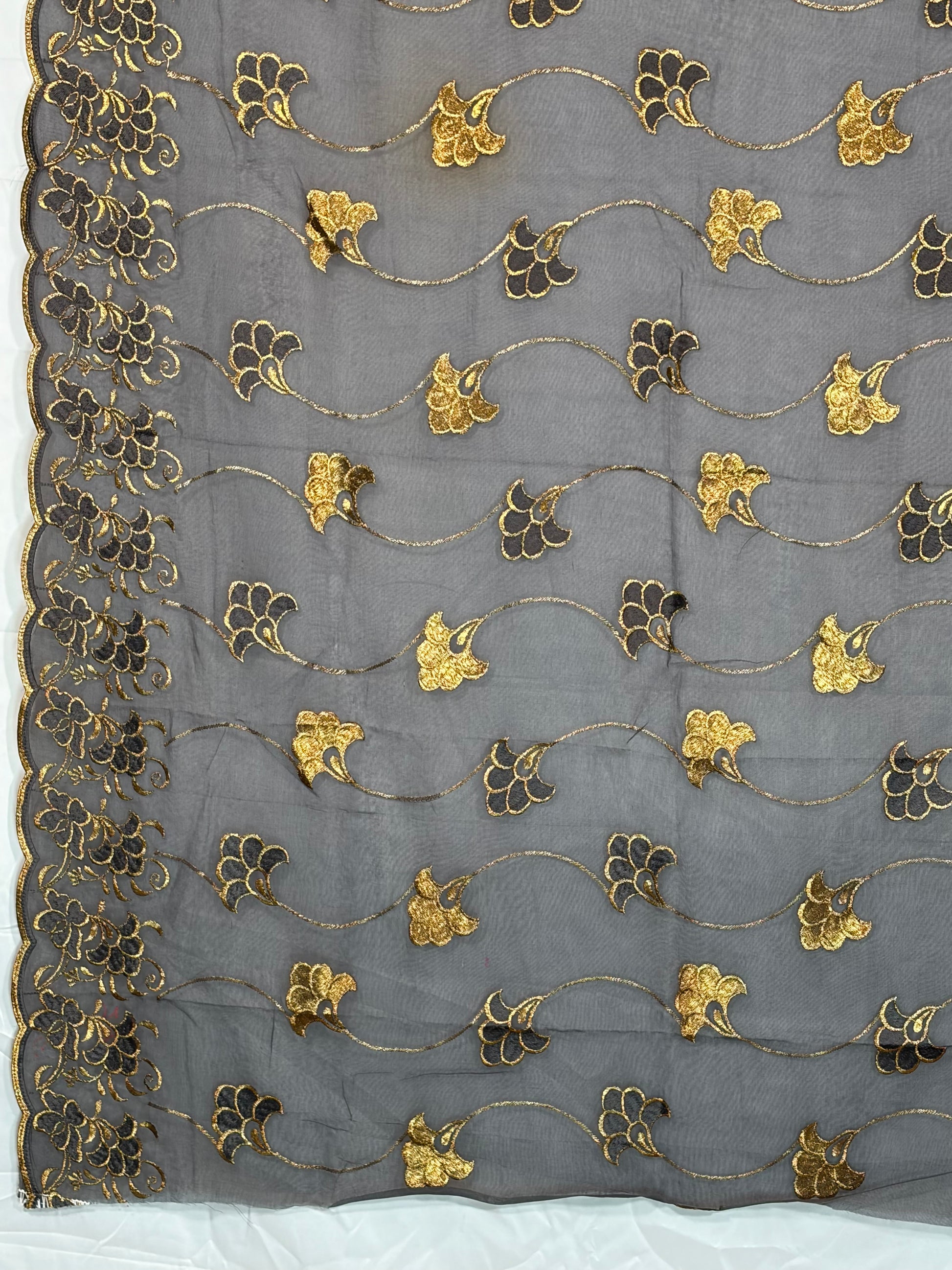 Decorative fabric with gold and black floral patterns on a gray background